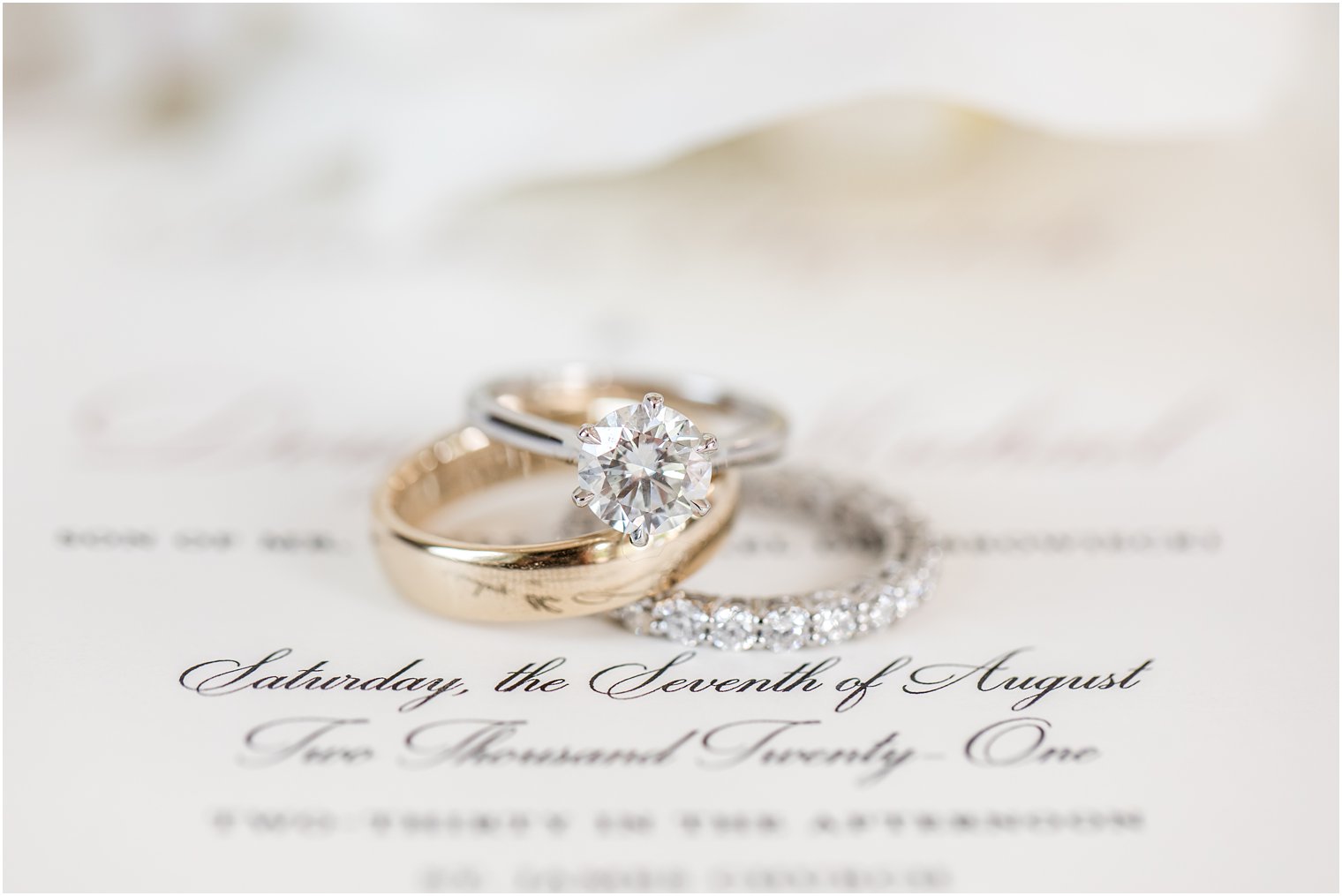 wedding bands lay on classic invitation for NJ wedding day