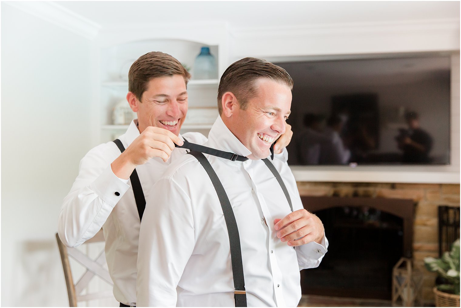groomsman helps groom put on bowtie for NJ wedding