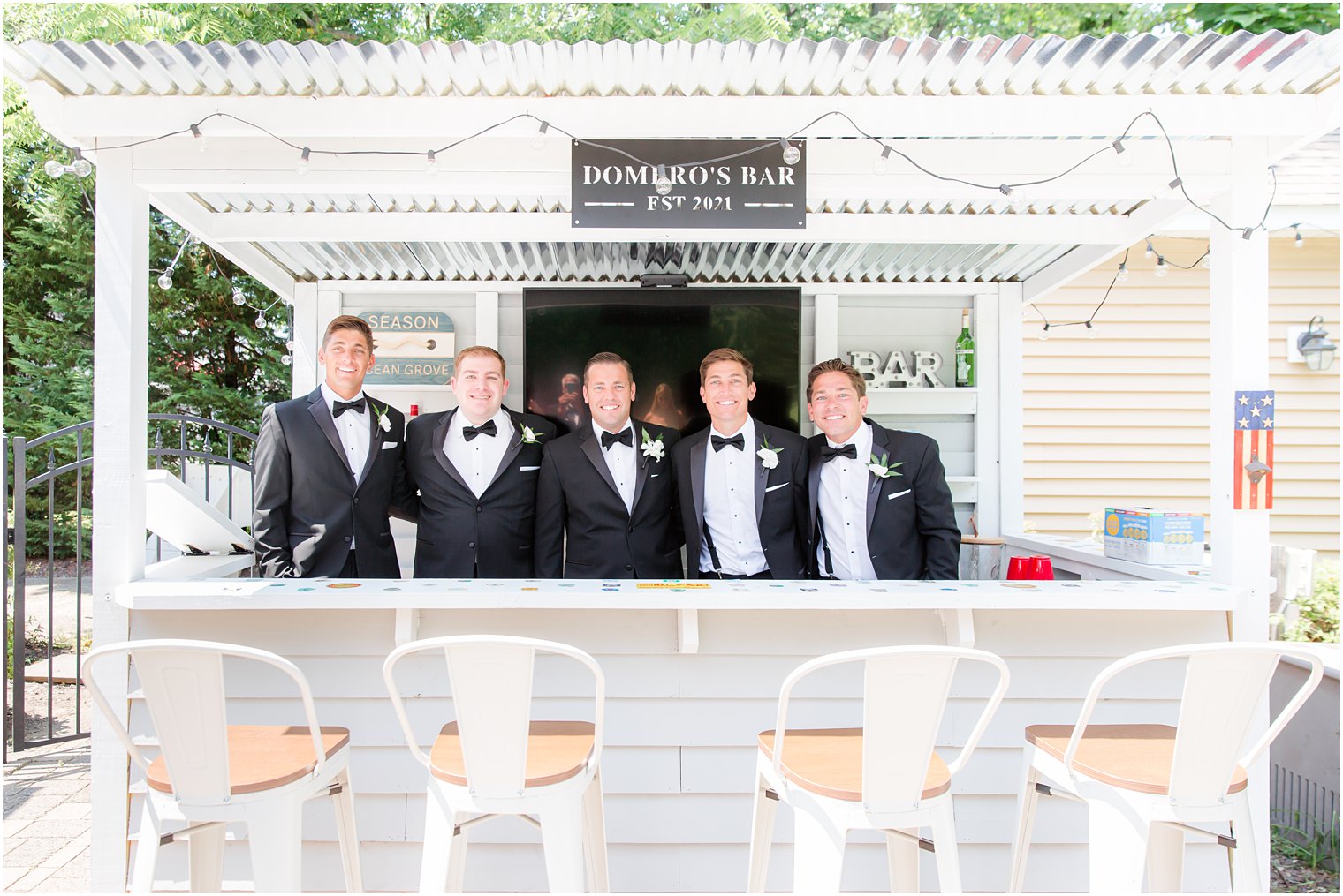 groom poses with groomsmen at bar