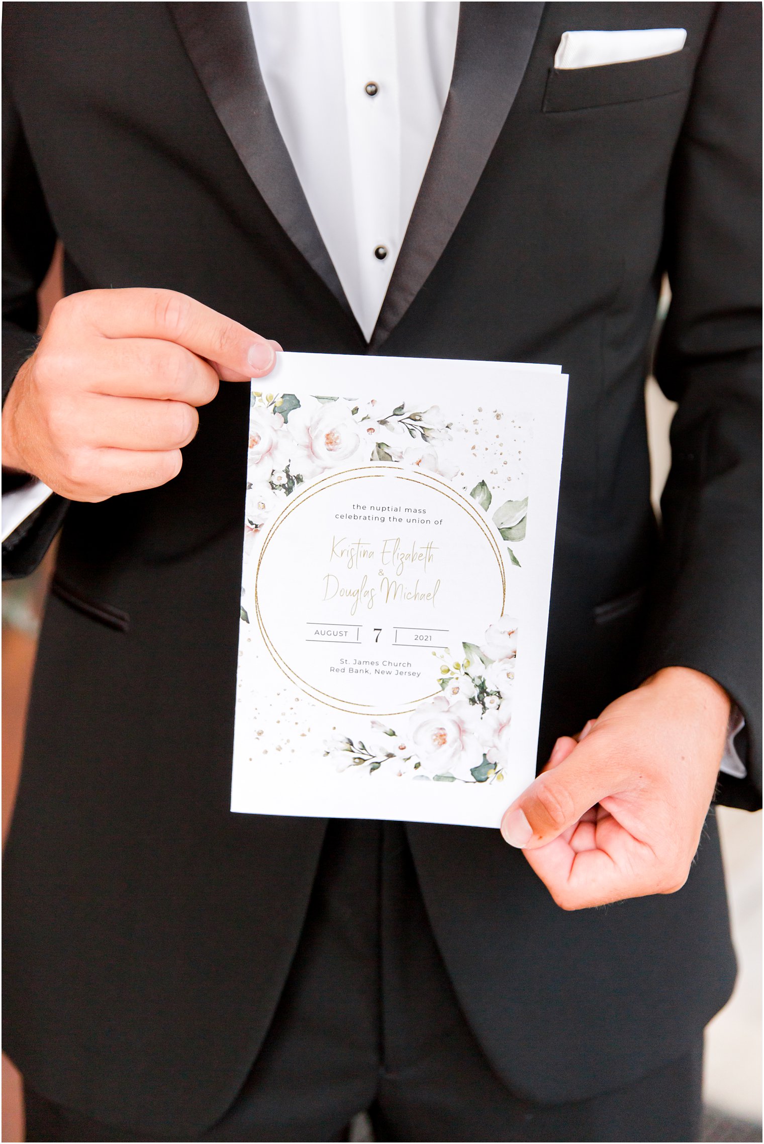 groom holds wedding invitation for Red Bank NJ celebration