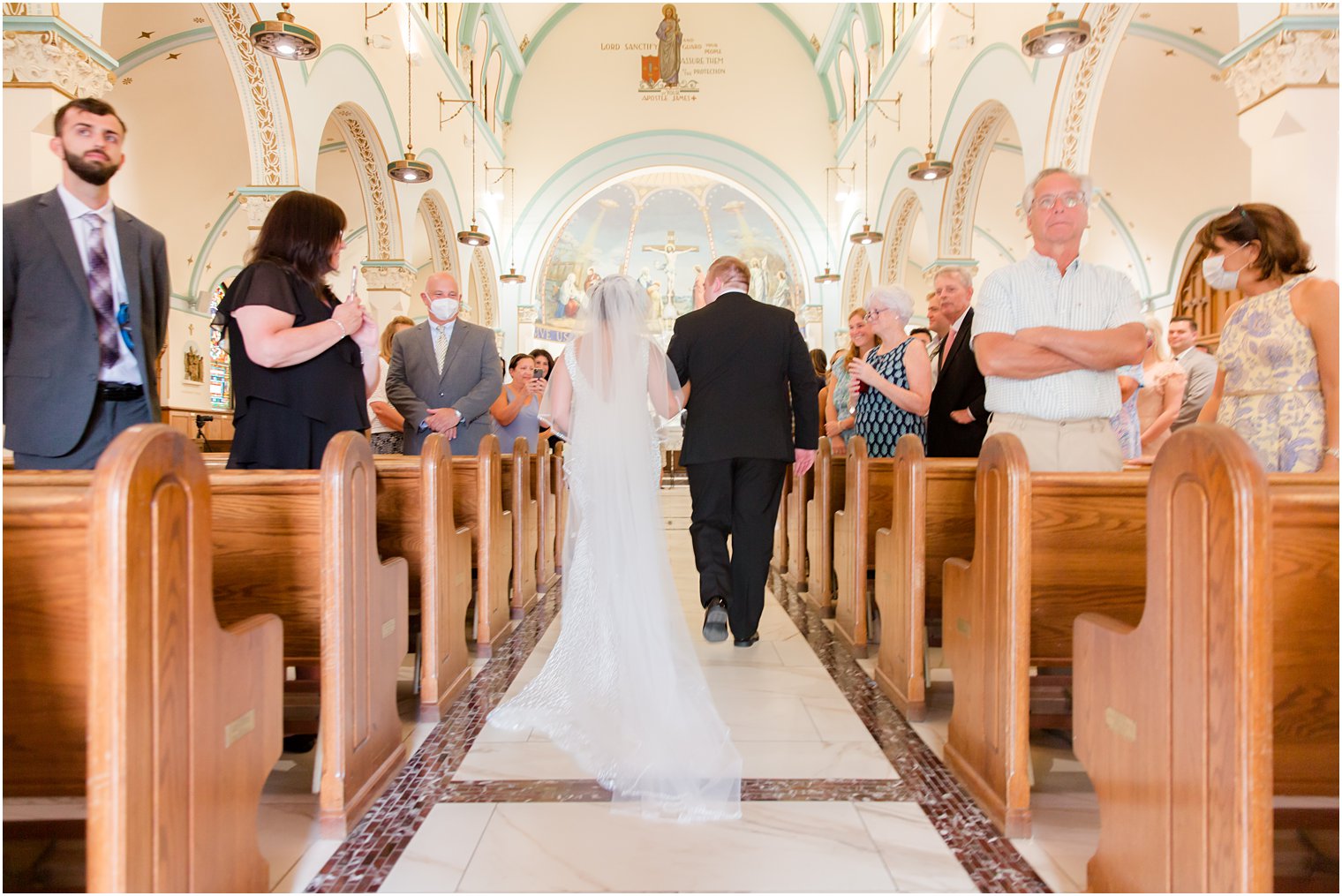 bride walks down aisle for traditional wedding ceremony at St. James church