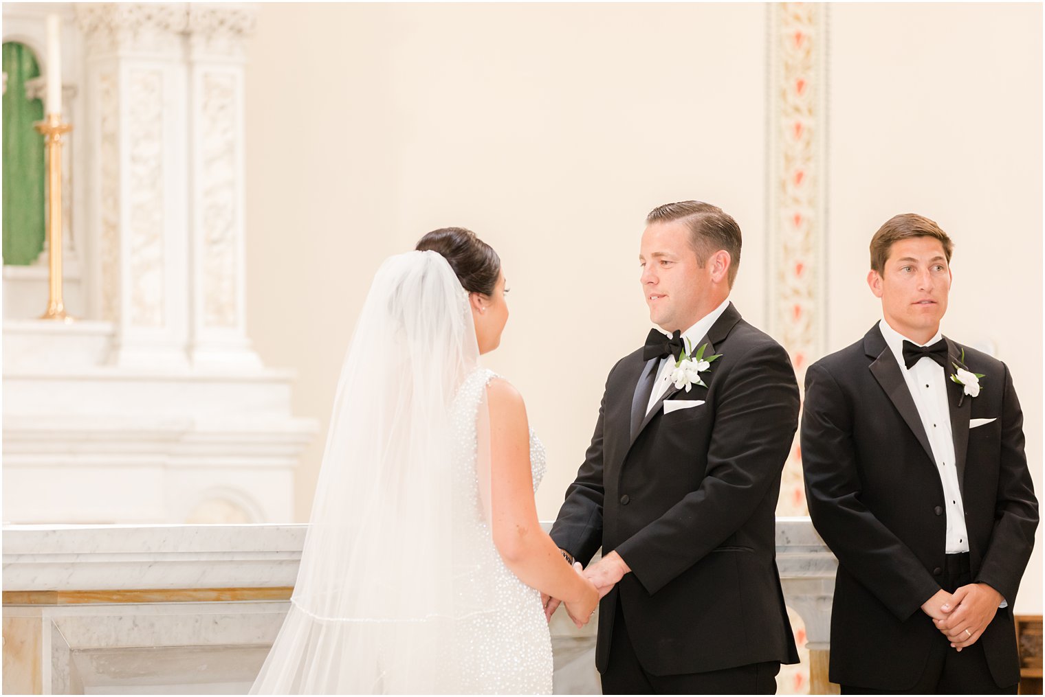 newlyweds hold hands during traditional wedding ceremony at St. James church