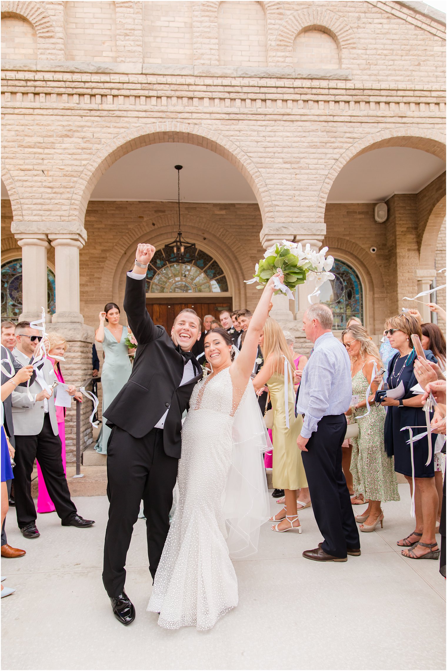 newlyweds cheer after traditional wedding ceremony at St. James church