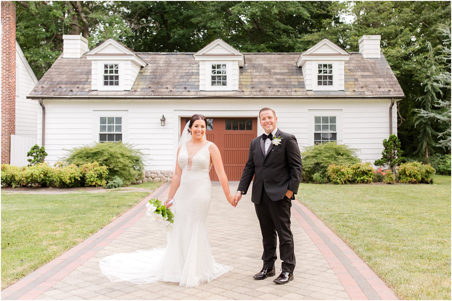 newlyweds hold hands walking through The English Manor