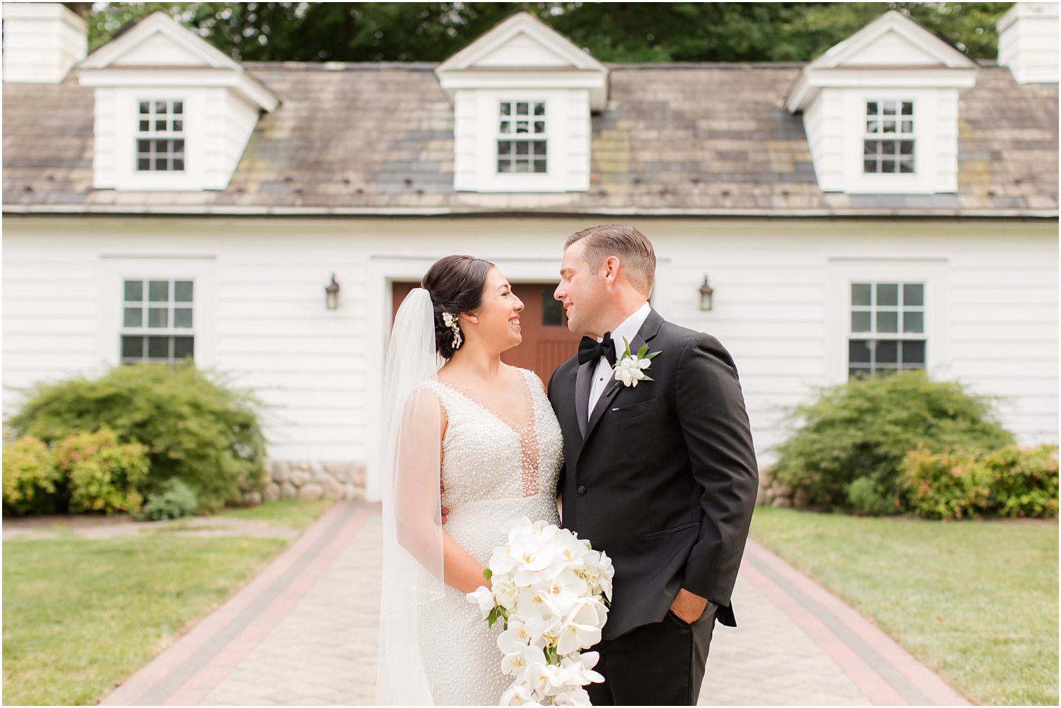 bride and groom laugh outside the English Manor photographed by Ocean Township NJ wedding photographer Idalia Photography