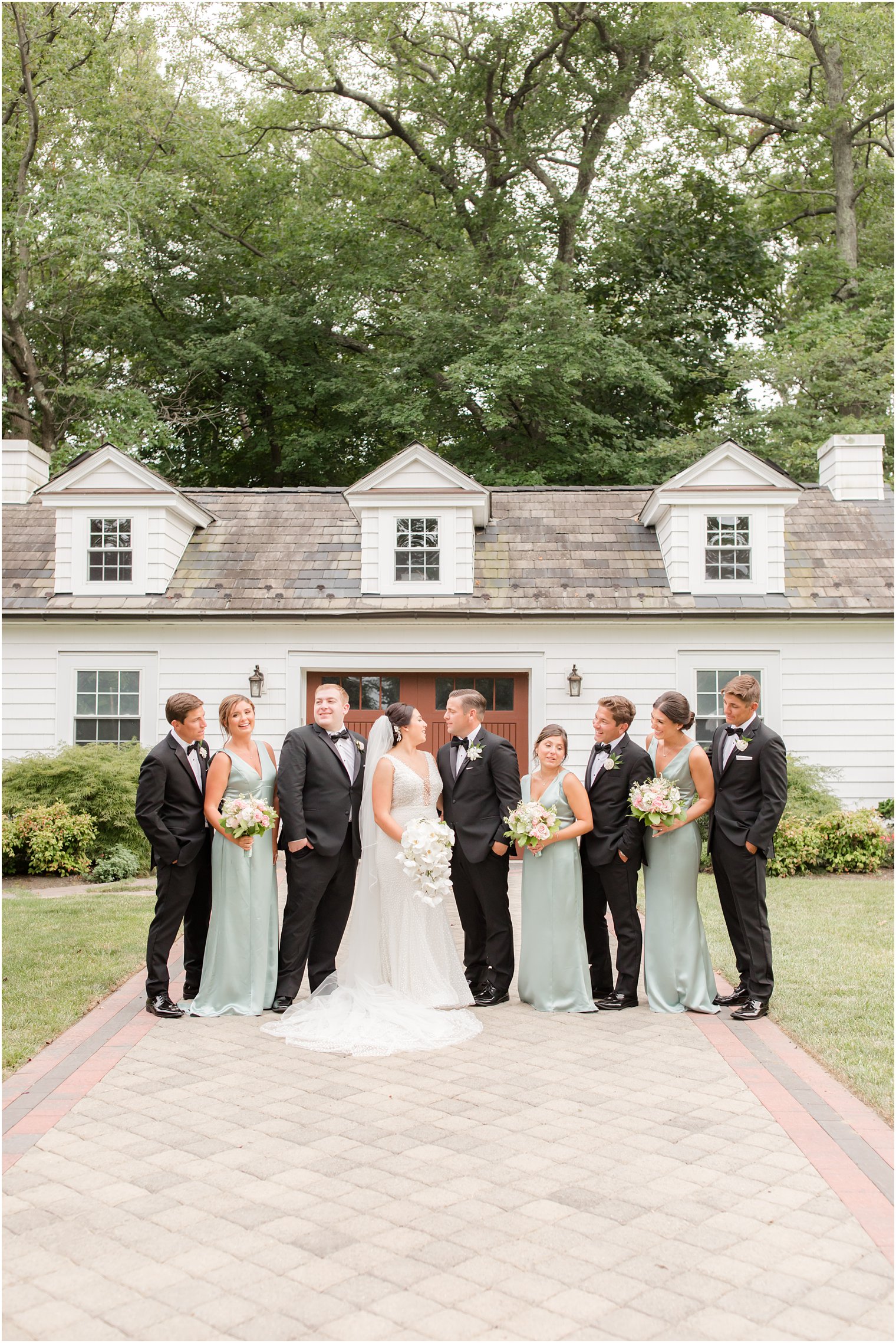 wedding party in mint and black smiles with bride and groom 