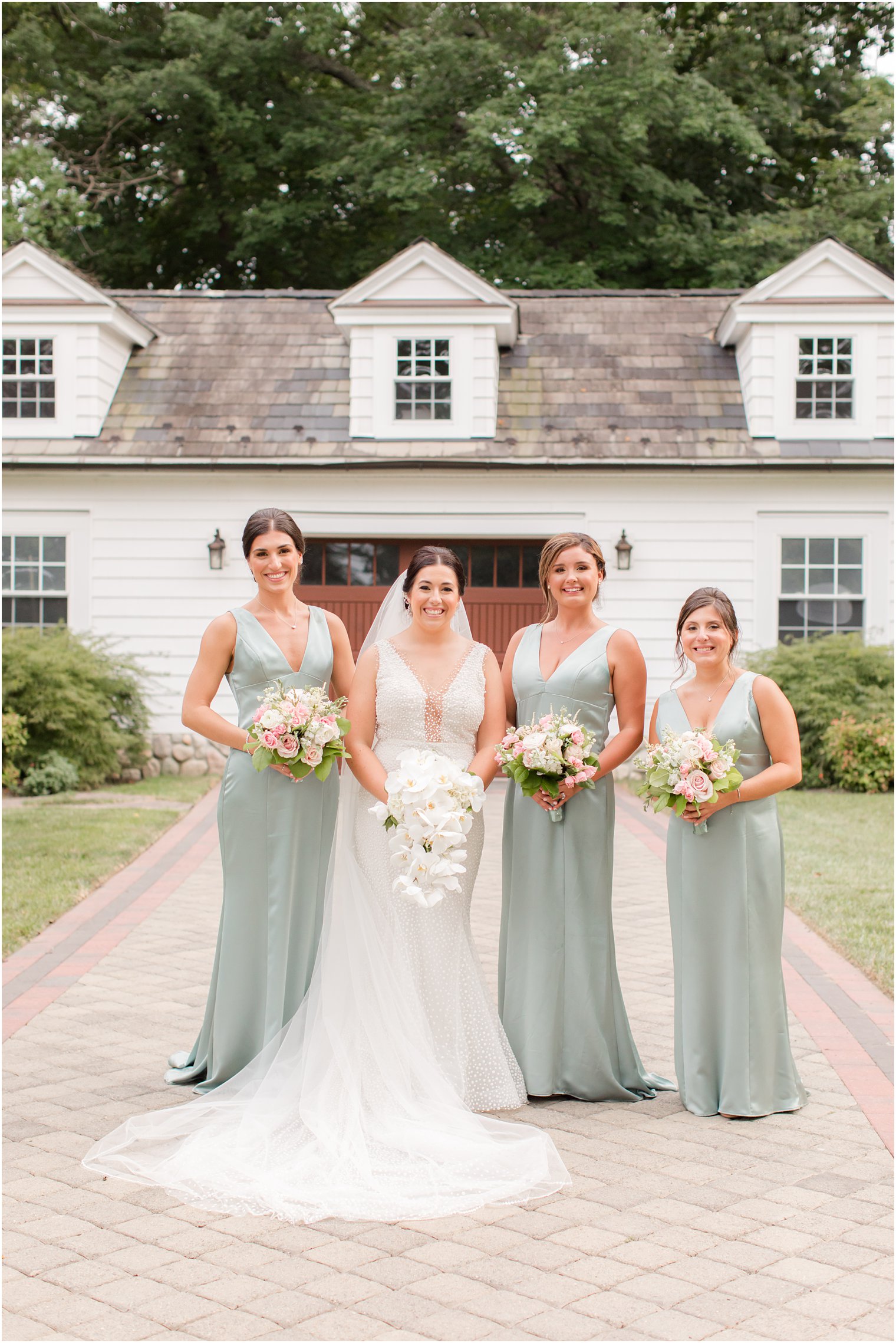 bride and bridesmaids in mint dresses pose outside The English Manor