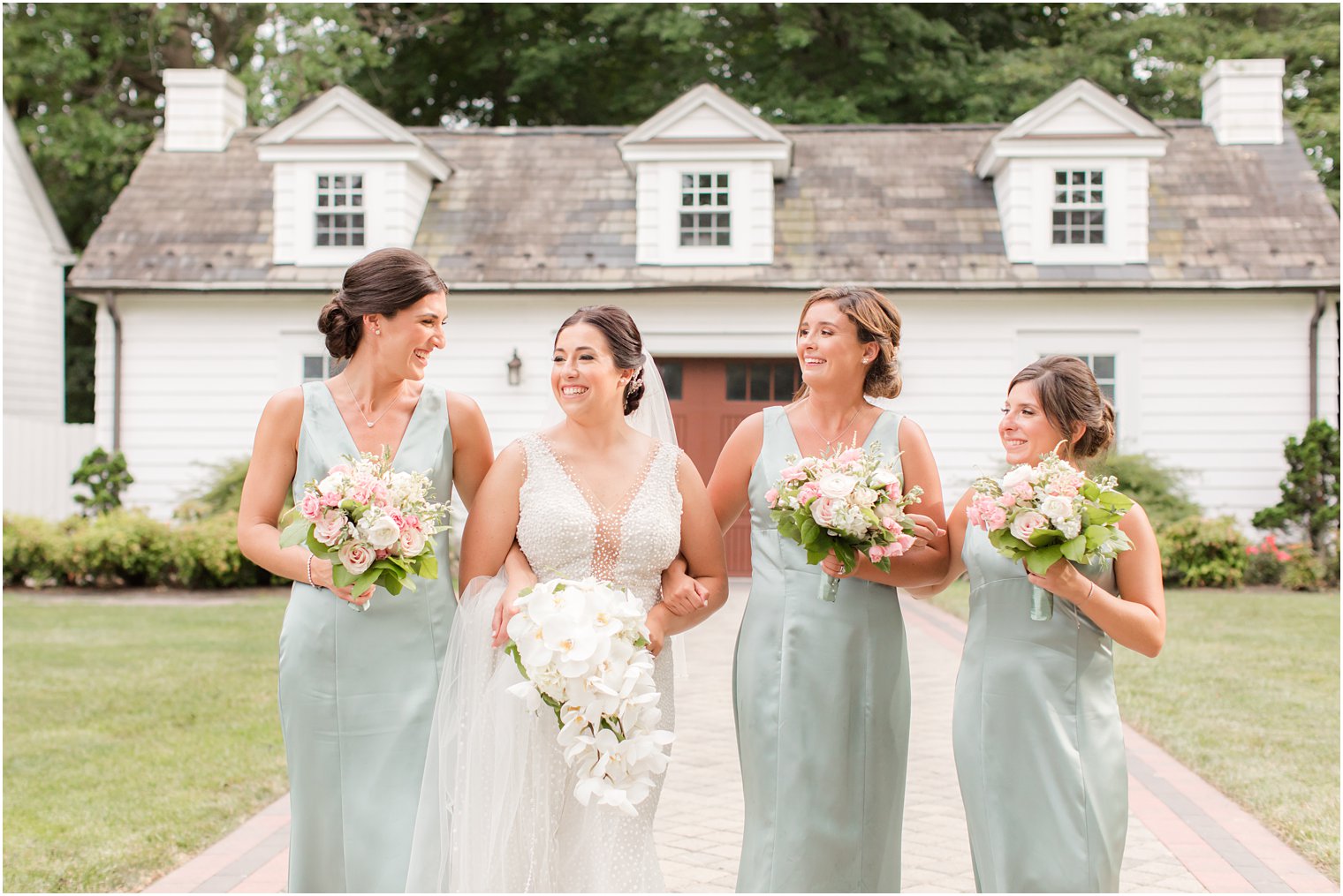 bride walks with bridesmaids in mint green gowns