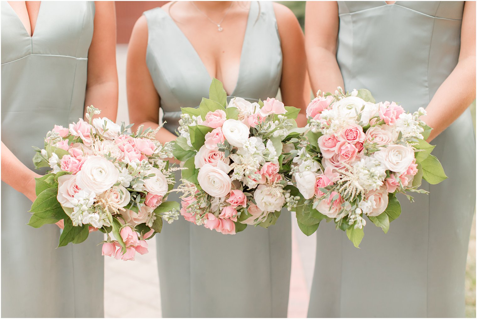 bridesmaids hold bouquets of pink and white flowers 
