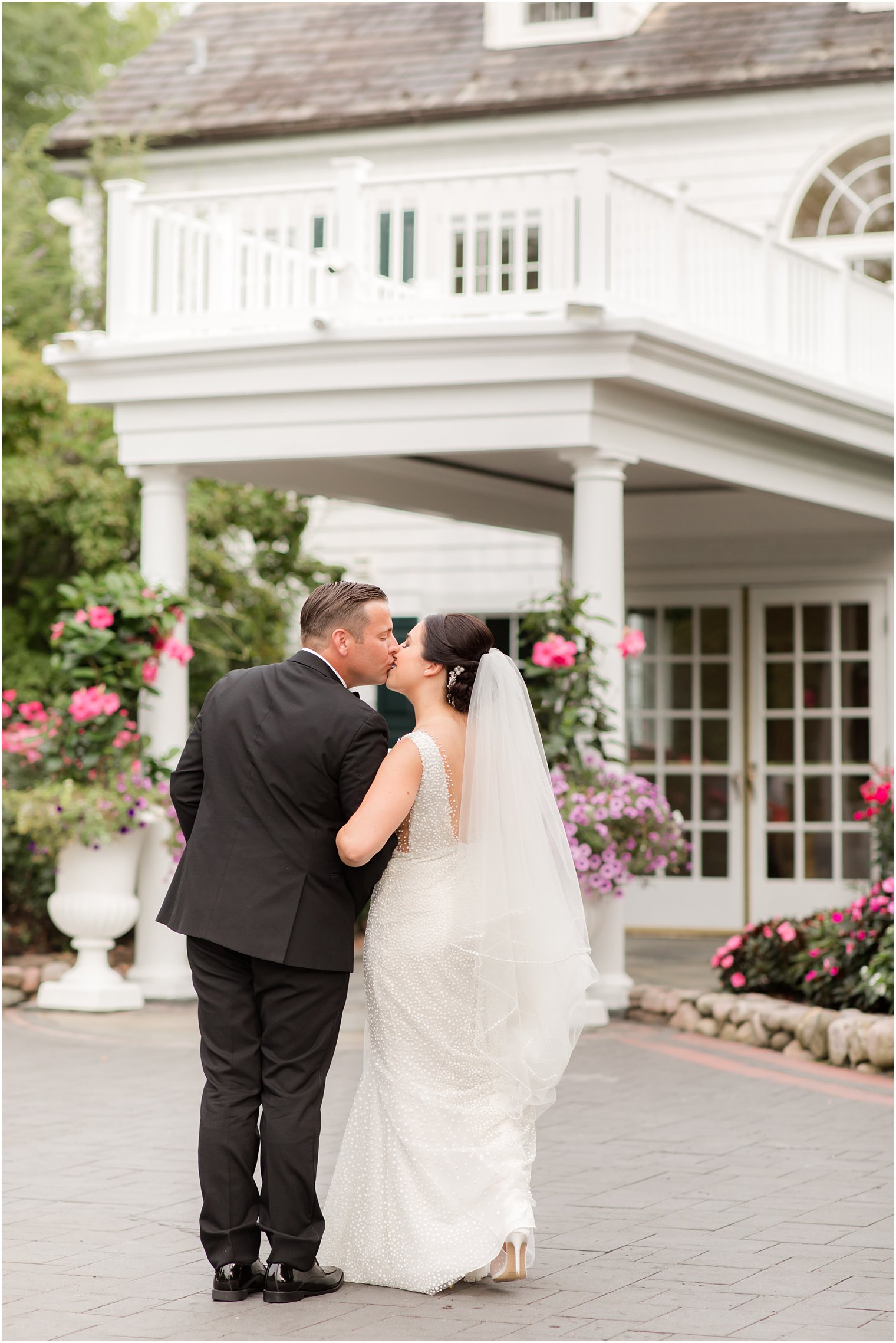 newlyweds walk outside The English Manor kissing 