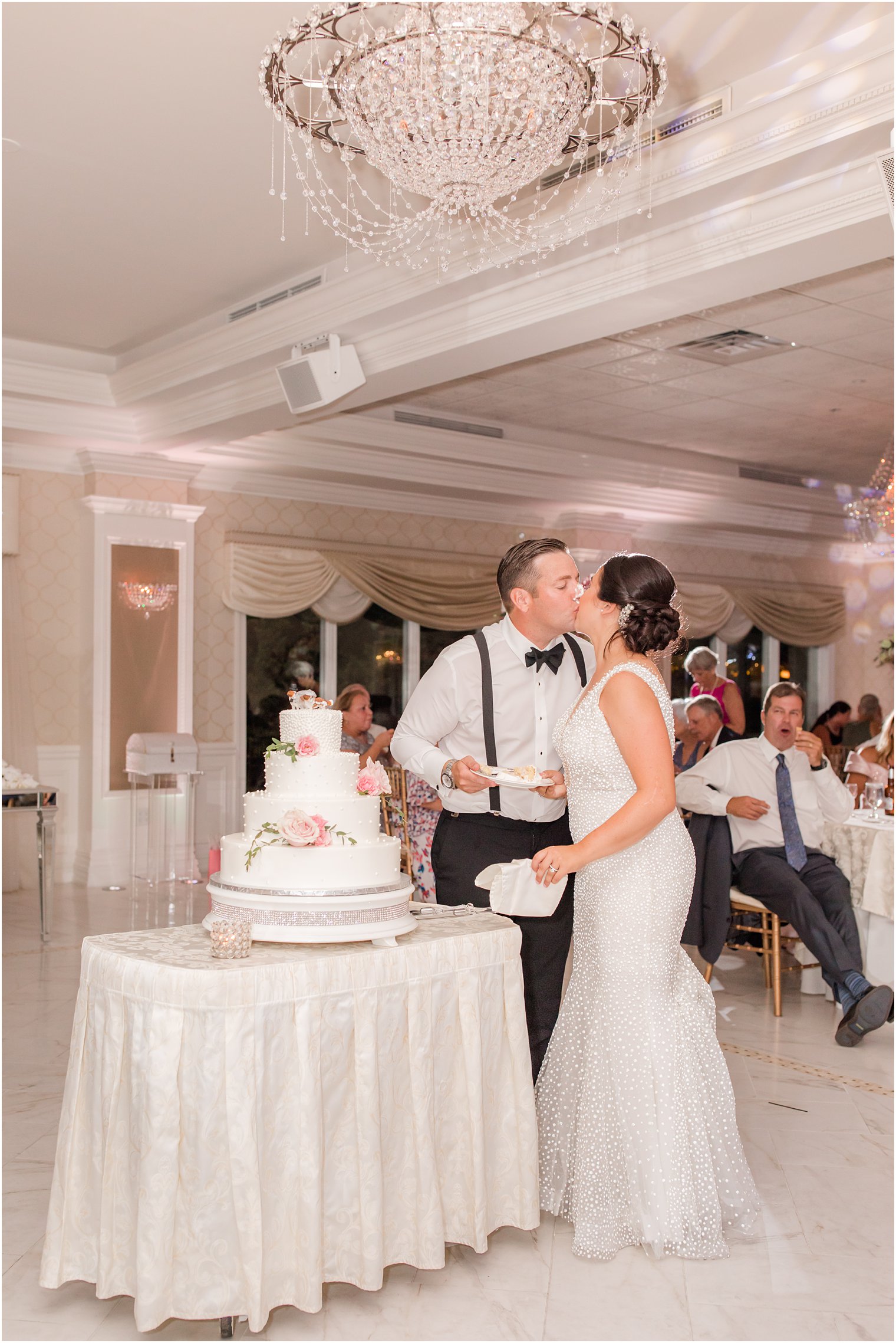 newlyweds kiss during cake cutting photographed by Ocean Township NJ wedding photographer