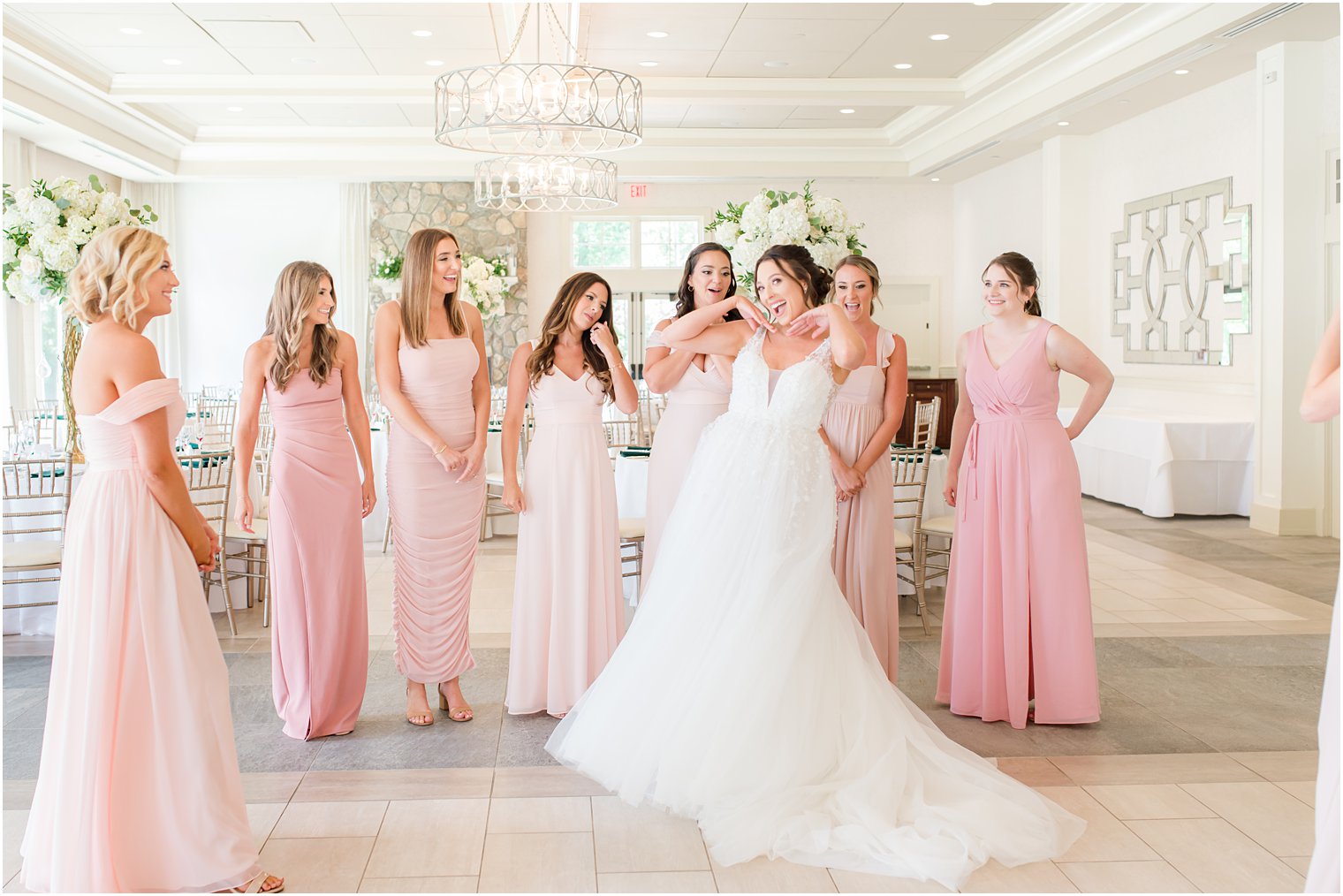 bride poses for bridesmaids in ballroom at Indian Trail Club