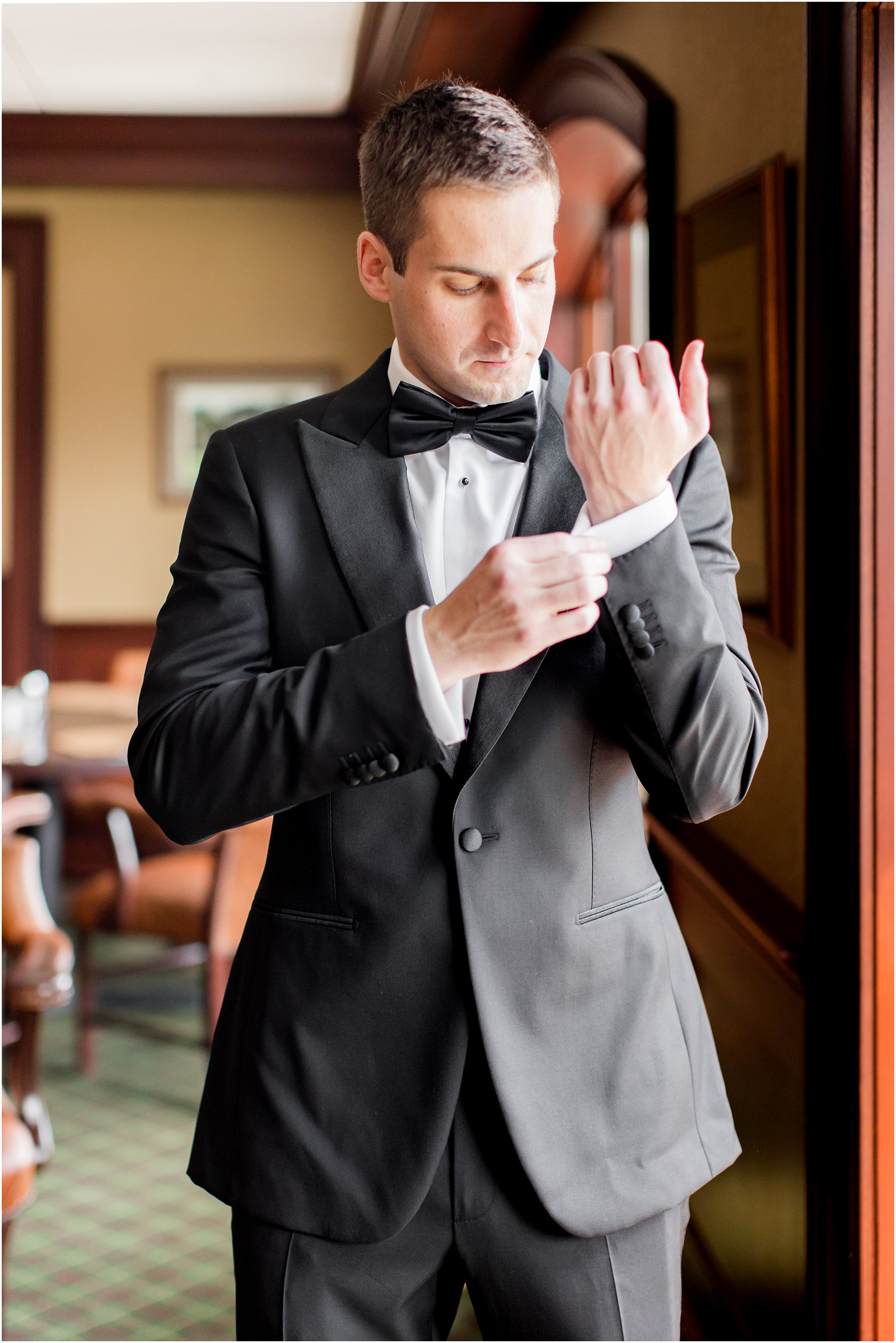 groom adjusts cufflinks before NJ wedding day