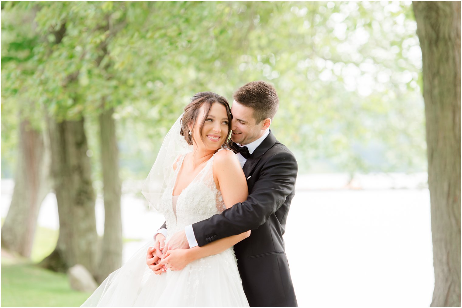 groom hugs bride during NJ wedding photos by Indian Trail Club