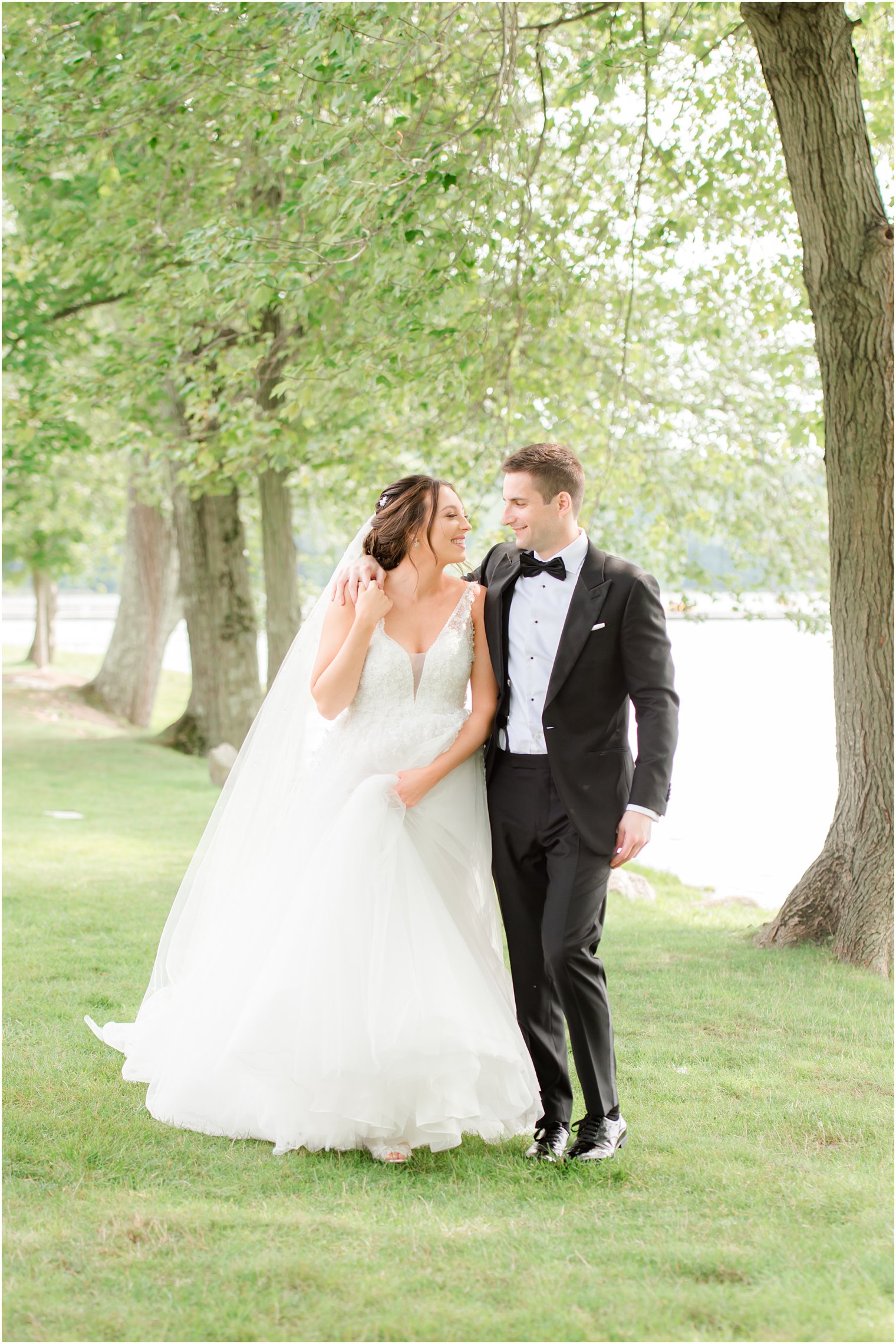 bride and groom walk along lake in Franklin Lakes NJ