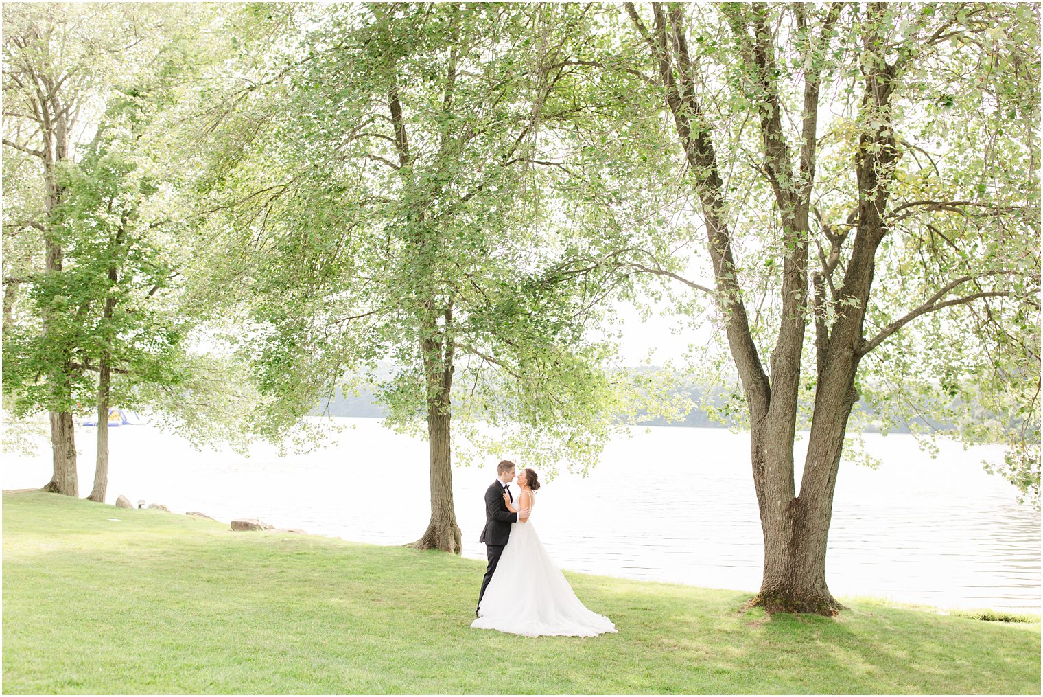 bride and groom pose under trees at Indian Trail Club