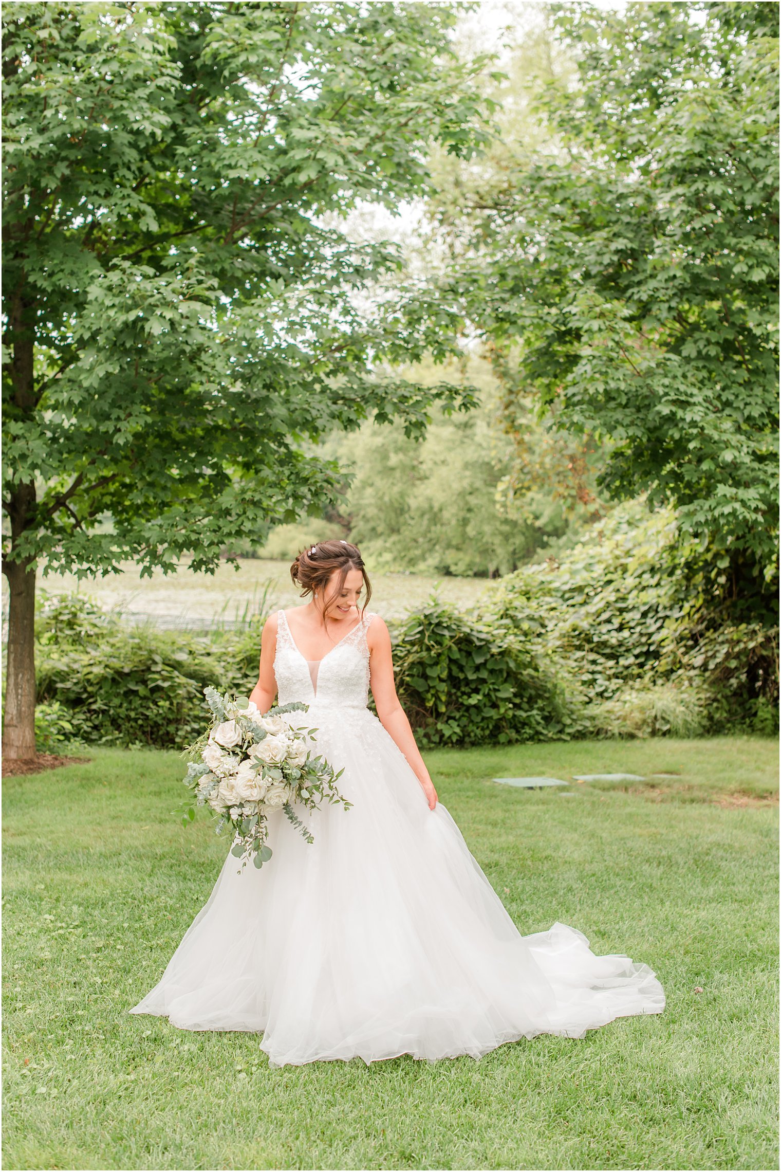 bride holds wedding dress at Indian Trail Club
