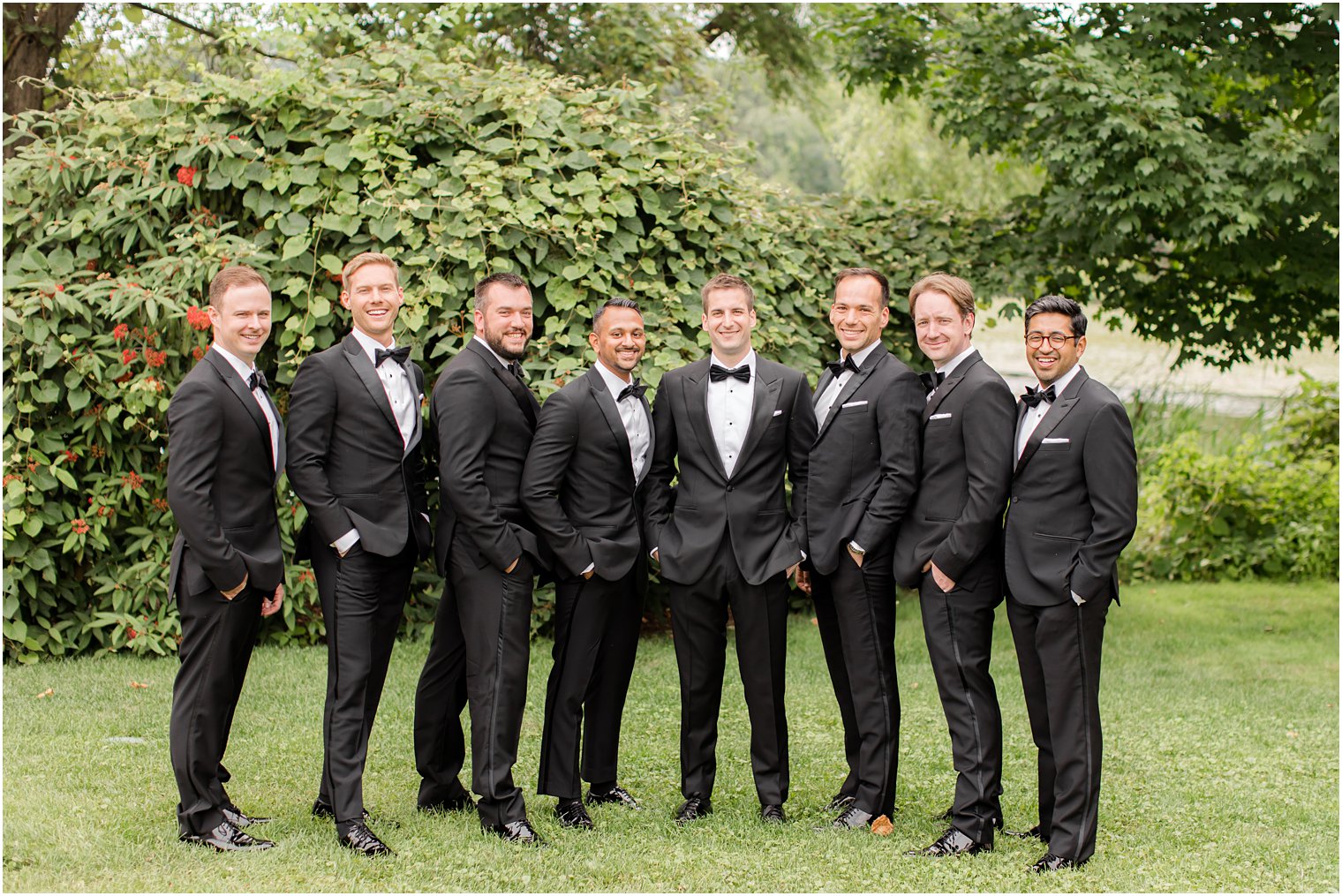 groom poses with groomsmen in classic black tuxes at Indian Trail Club