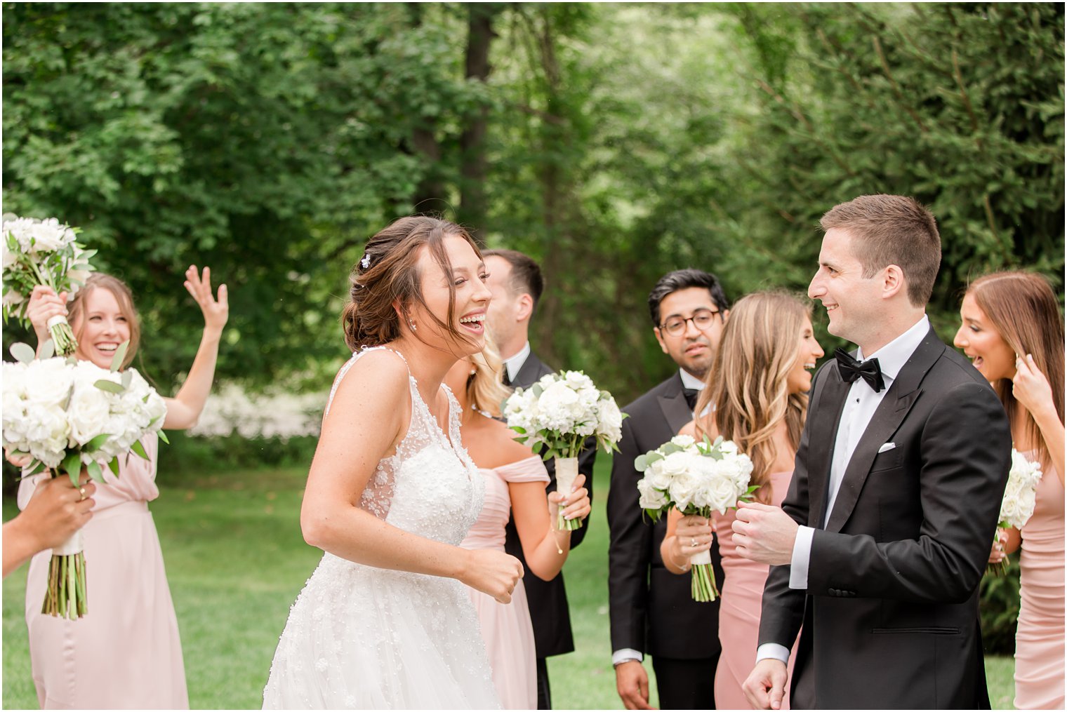 bride and groom laugh with wedding party during Franklin Lakes NJ wedding day