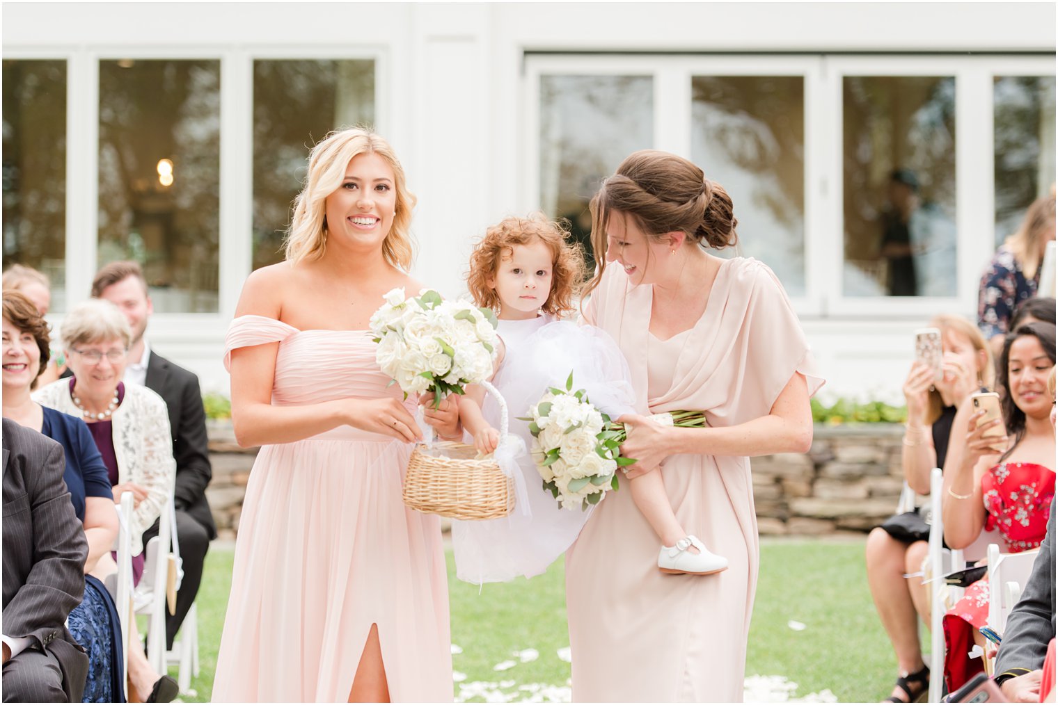bridesmaids walk down aisle with flower girl