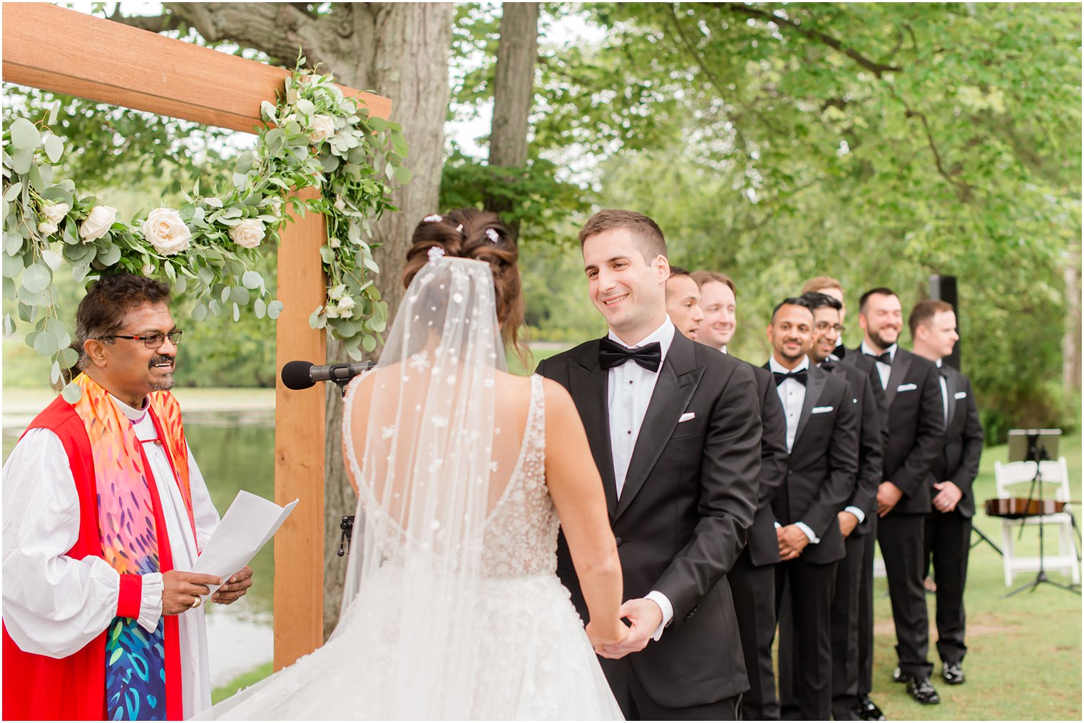 groom looks at bride during waterfront wedding ceremony in Franklin Lakes NJ