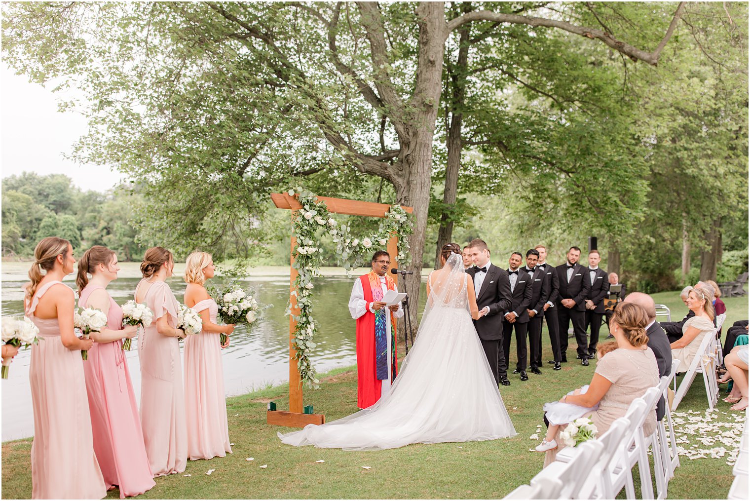 newlyweds hold hands together during waterfront wedding ceremony in Franklin Lakes NJ