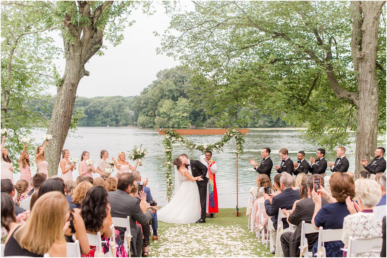 groom kisses bride during waterfront wedding ceremony in Franklin Lakes NJ