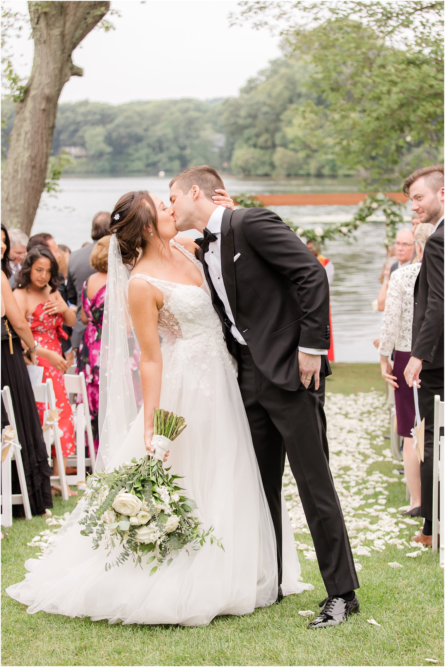 newlyweds kiss at the end of the aisle after waterfront wedding ceremony in Franklin Lakes NJ