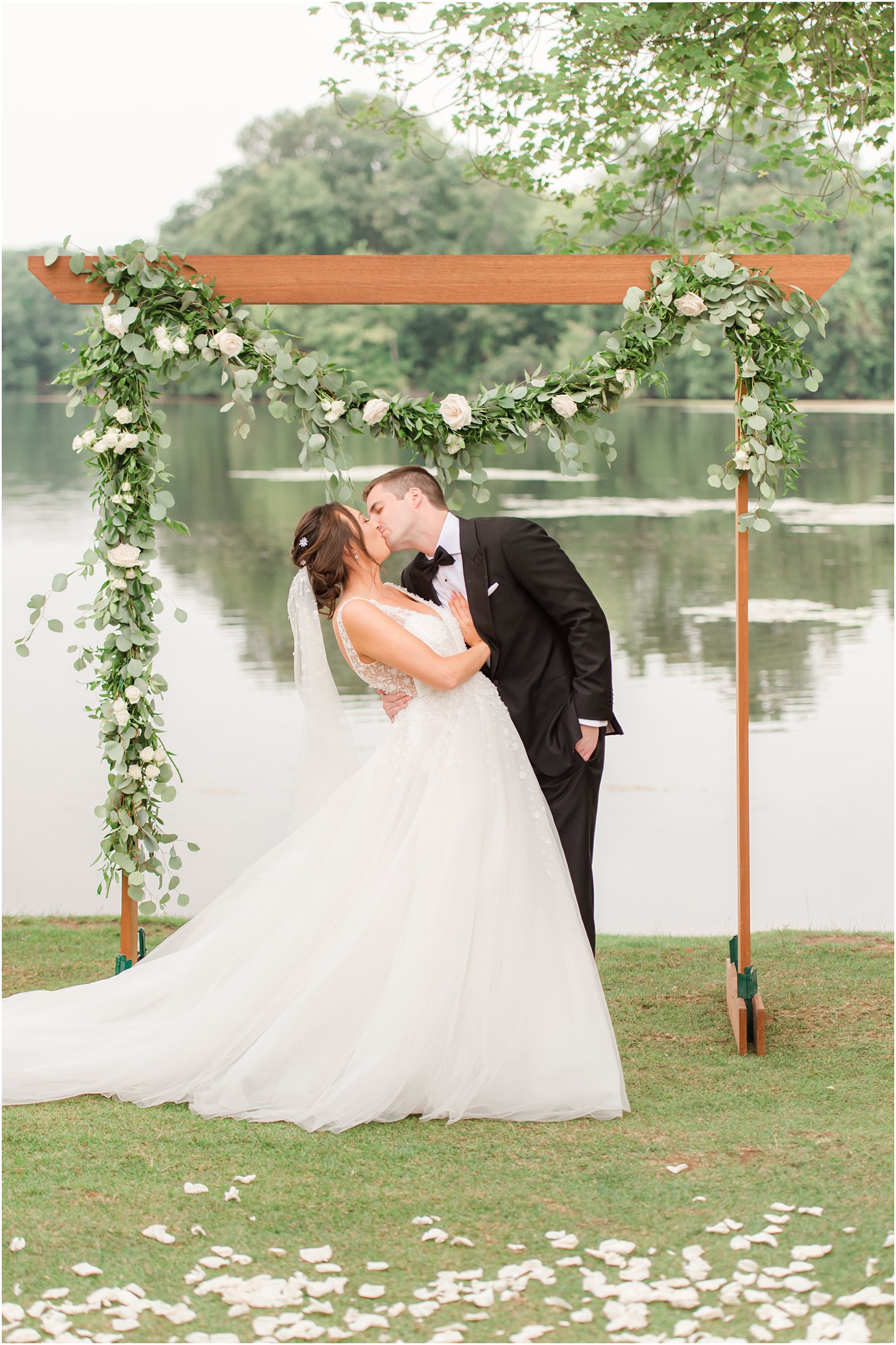 newlyweds kiss by wooden altar in Franklin Lakes NJ