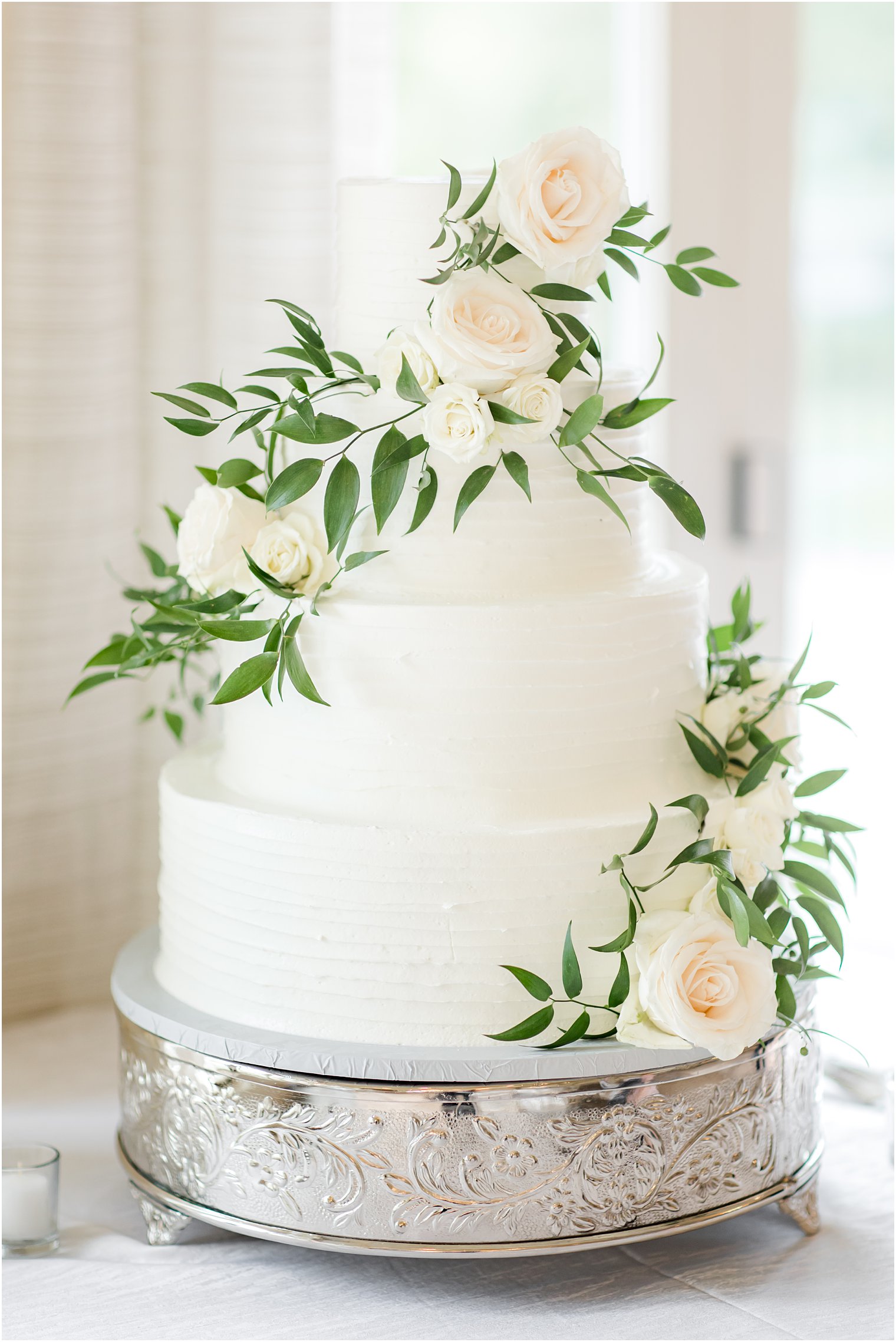 tiered wedding cake with ivory roses at Indian Trail Club