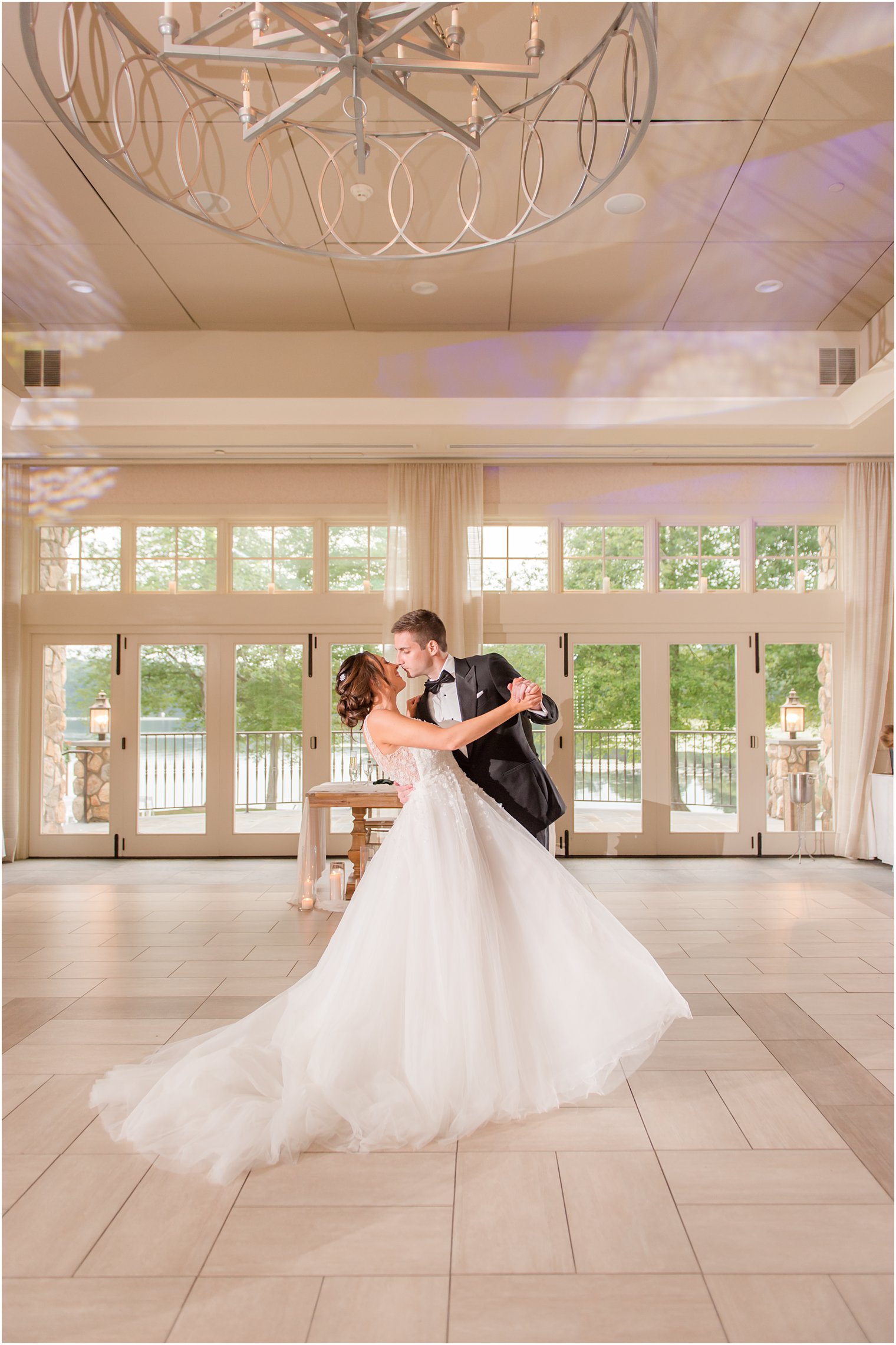 bride and groom kiss in ballroom at Indian Trail Club