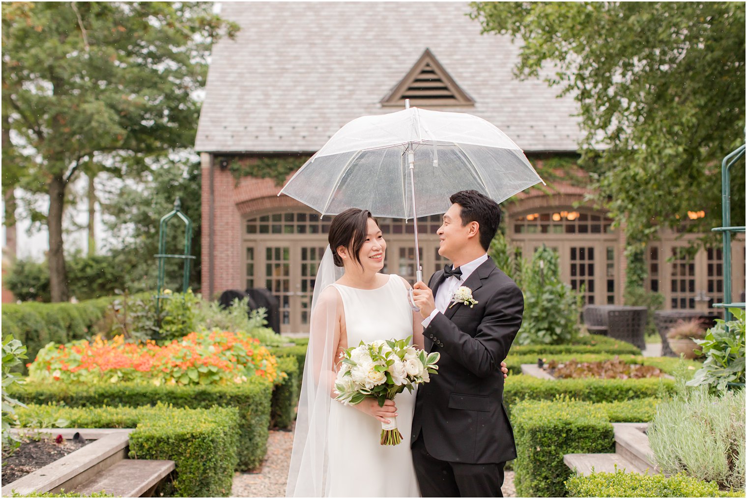 bride and groom laugh under umbrella at Ninety Acres