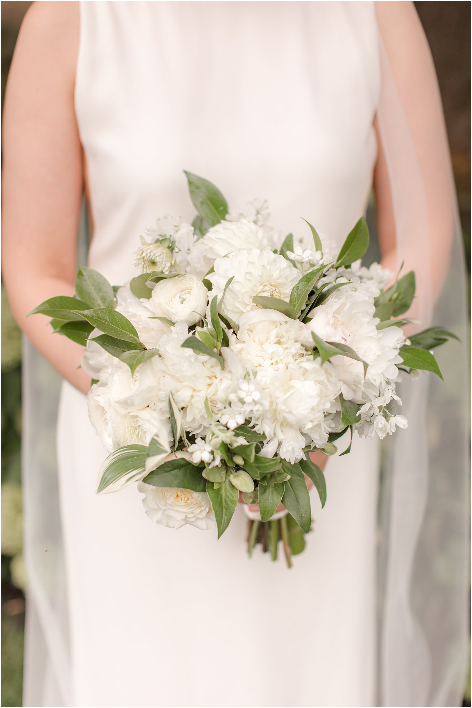 bride holds bouquet of white flowers for summer microwedding at Ninety Acres