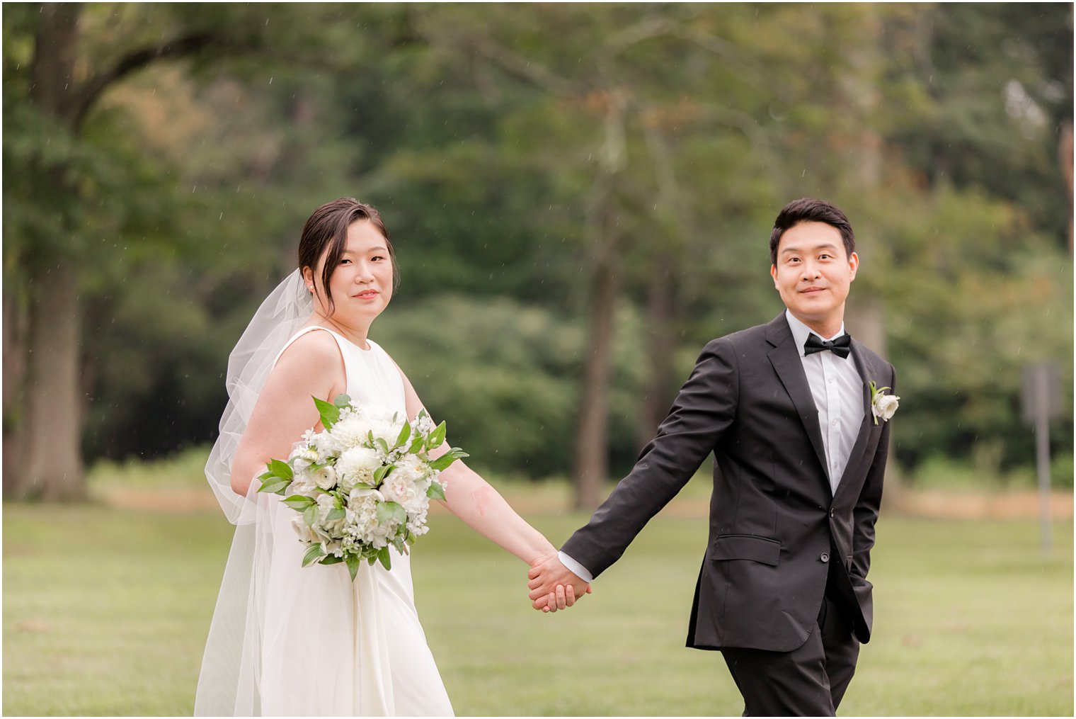 bride and groom hold hands walking through Ninety Acres