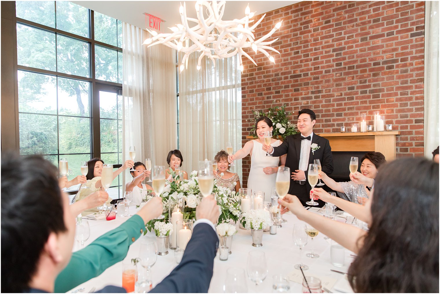newlyweds toast champagne with guests during dinner at microwedding at Ninety Acres