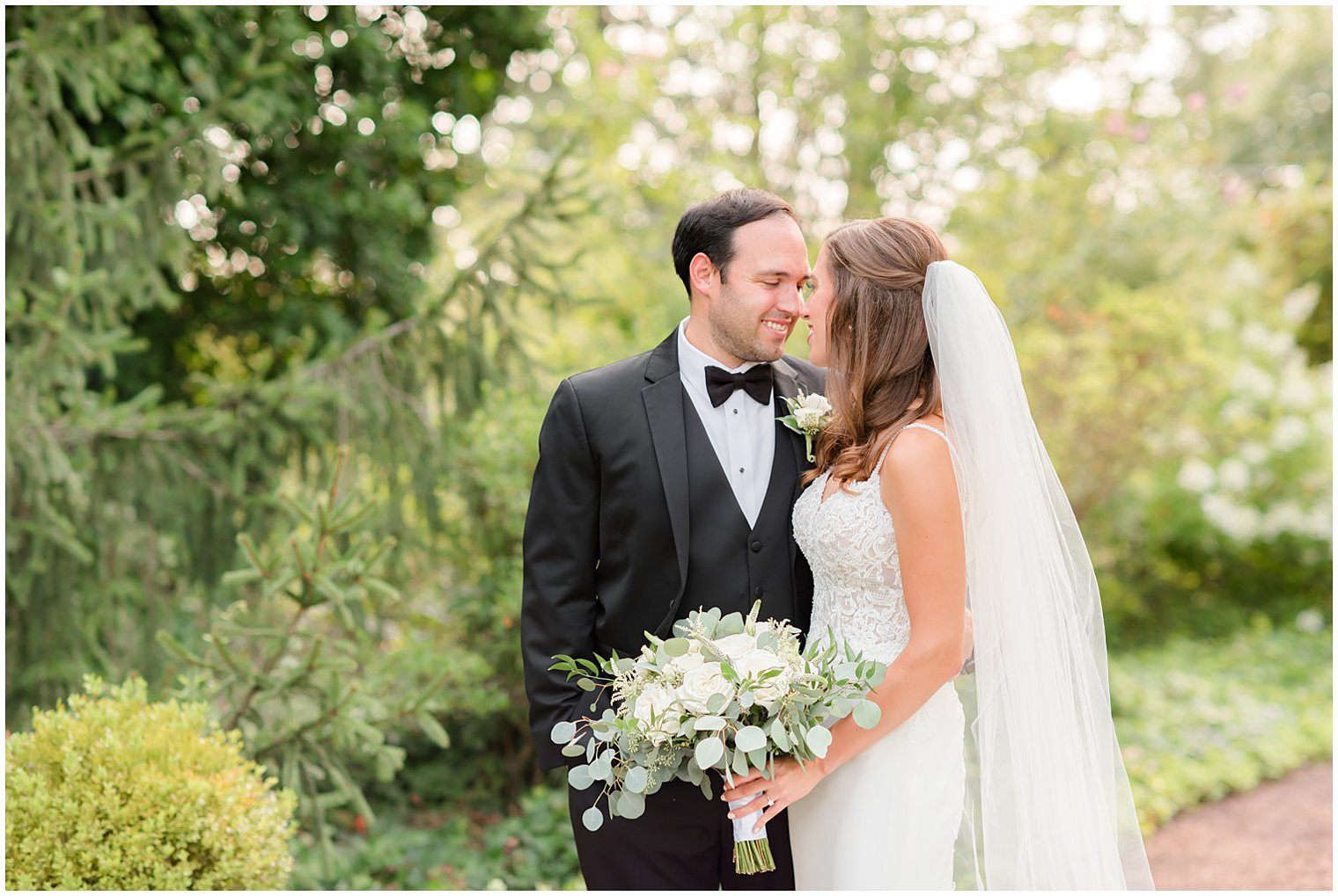 newlyweds stand with noses touching at the Inn at Fernbrook Farms