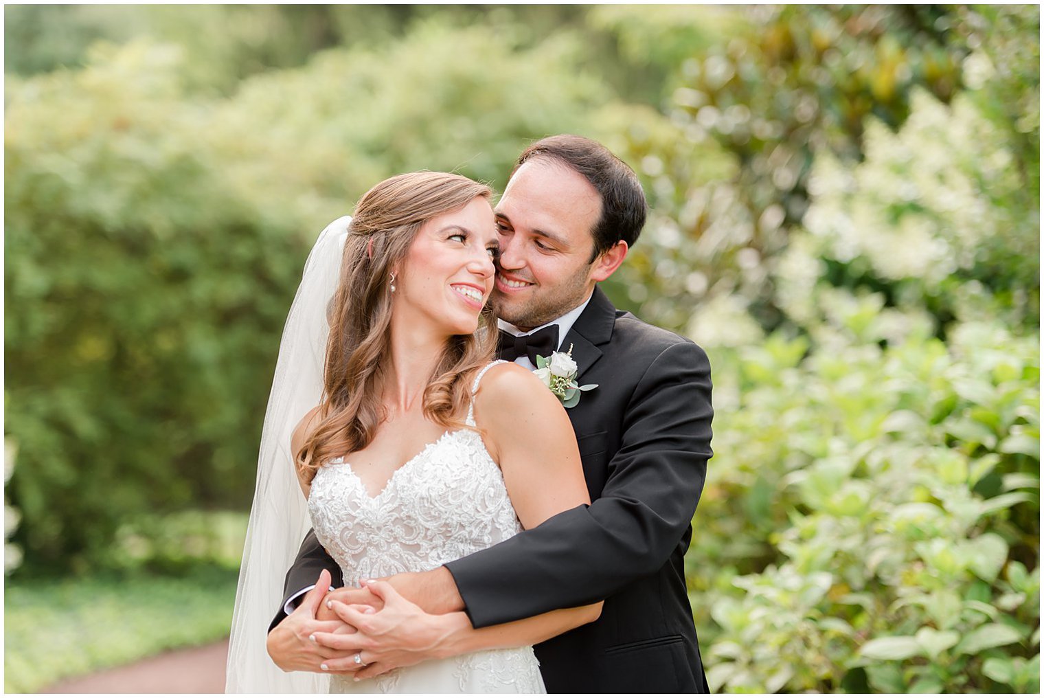 groom hugs bride from behind during portraits at the Inn at Fernbrook Farms