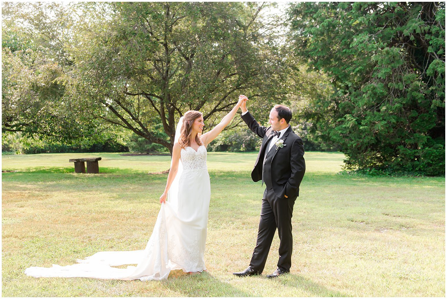 groom twirls bride during portraits at the Inn at Fernbrook Farms