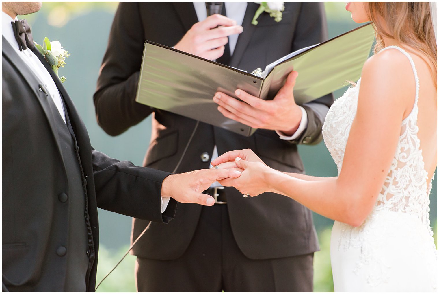 bride puts ring on groom's finger during NJ wedding ceremony