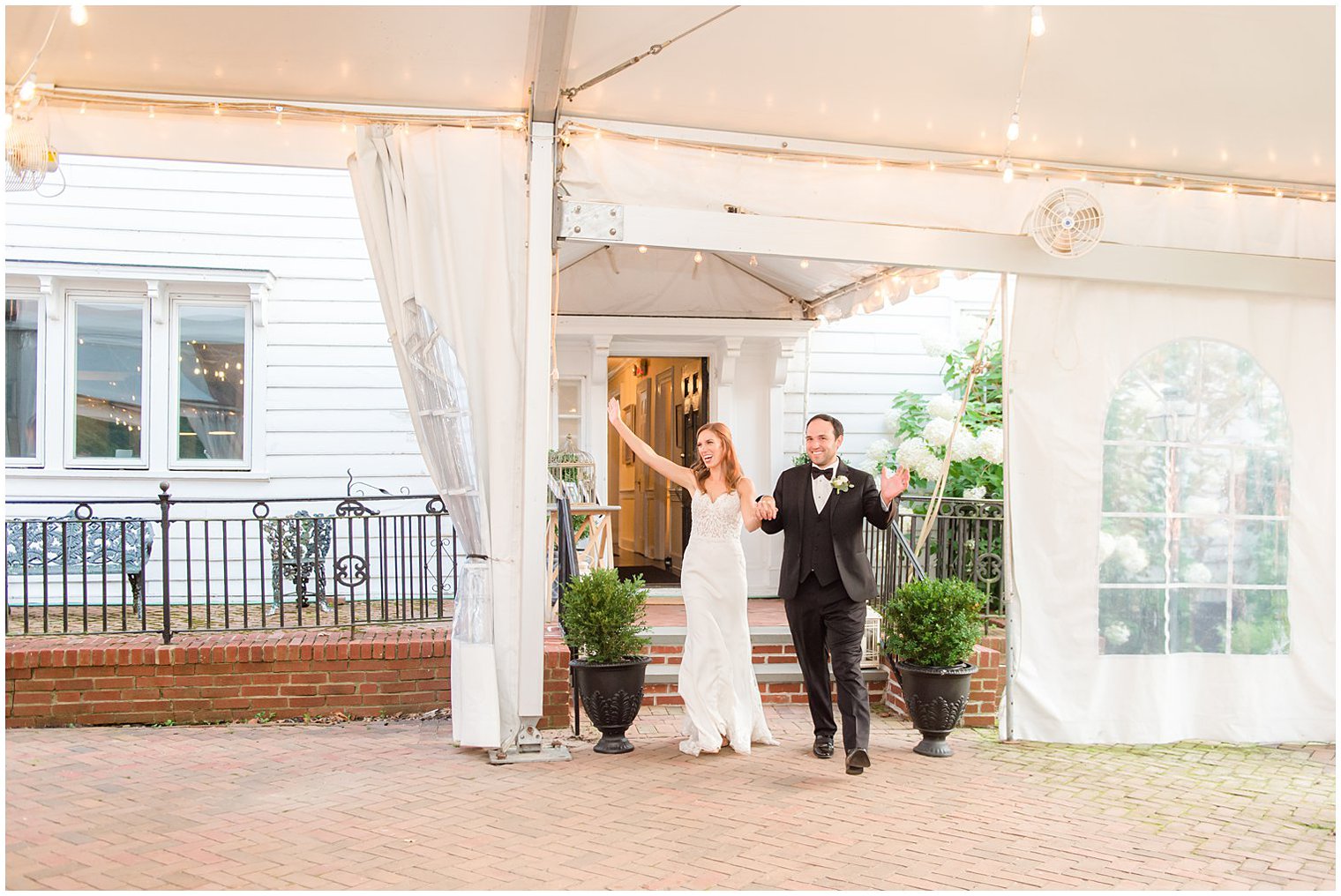 newlyweds enter tented wedding reception at the Inn at Fernbrook Farms