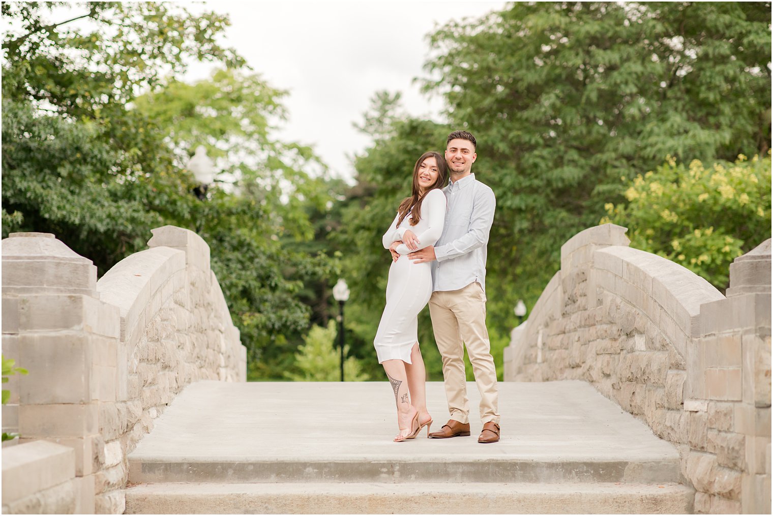 couple hugs on the bridge during Verona Park engagement session