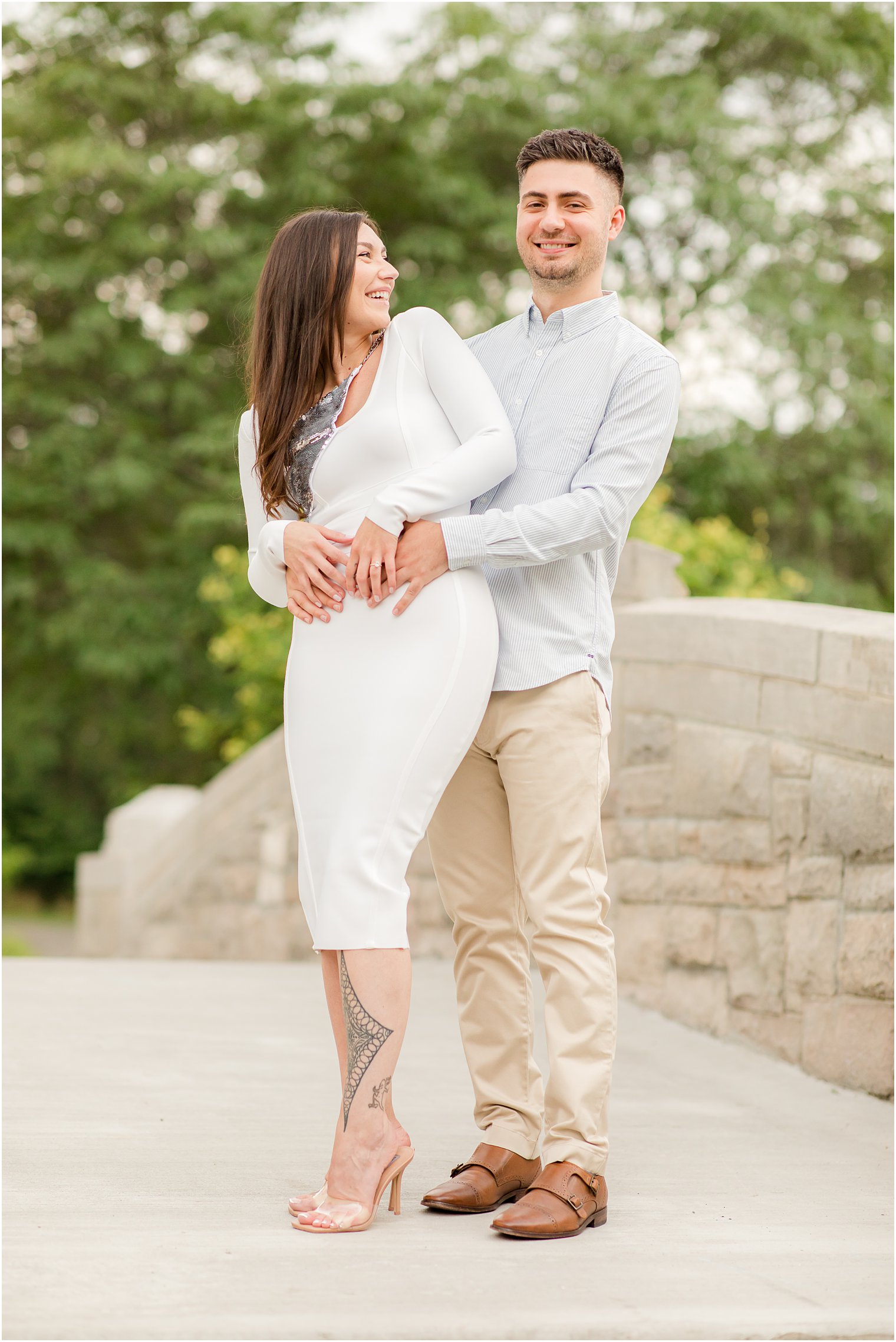 bride and groom pose on bridge during NJ engagement photos