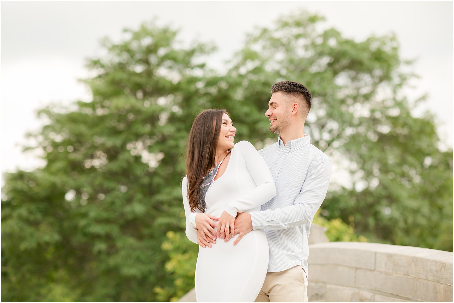 groom hugs bride on bridge during Verona Park engagement session