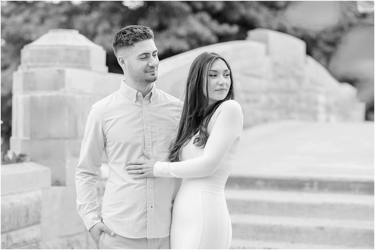 engaged couple hugs by steps in Verona Park 