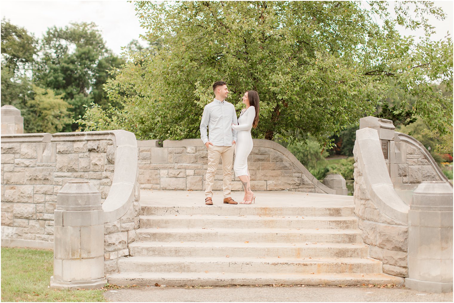 engaged couple stands on top of staircase at Verona Park