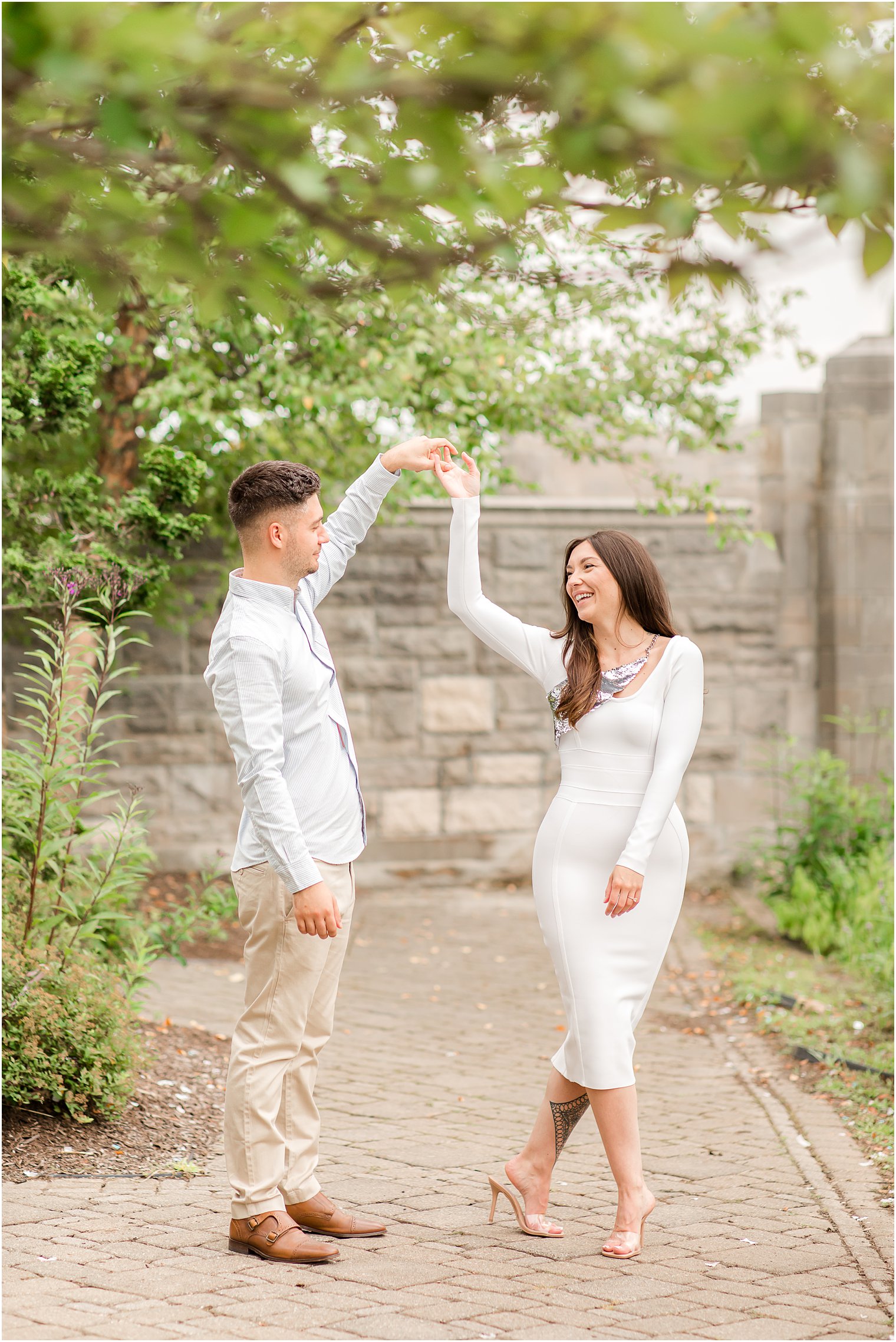 groom twirls bride during NJ engagement session in park