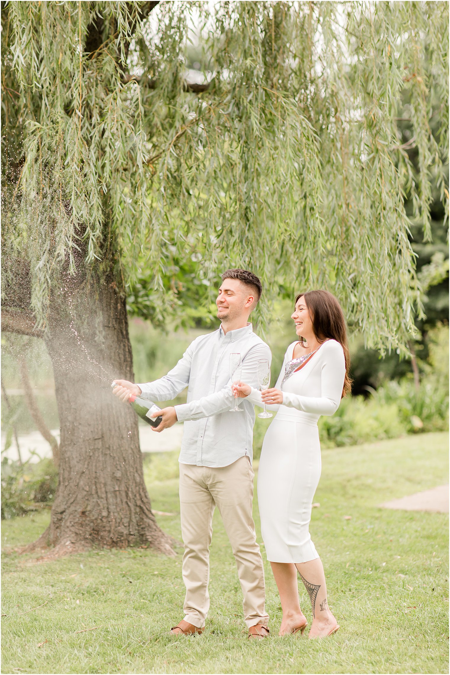 engaged couple laughs during champagne popping 