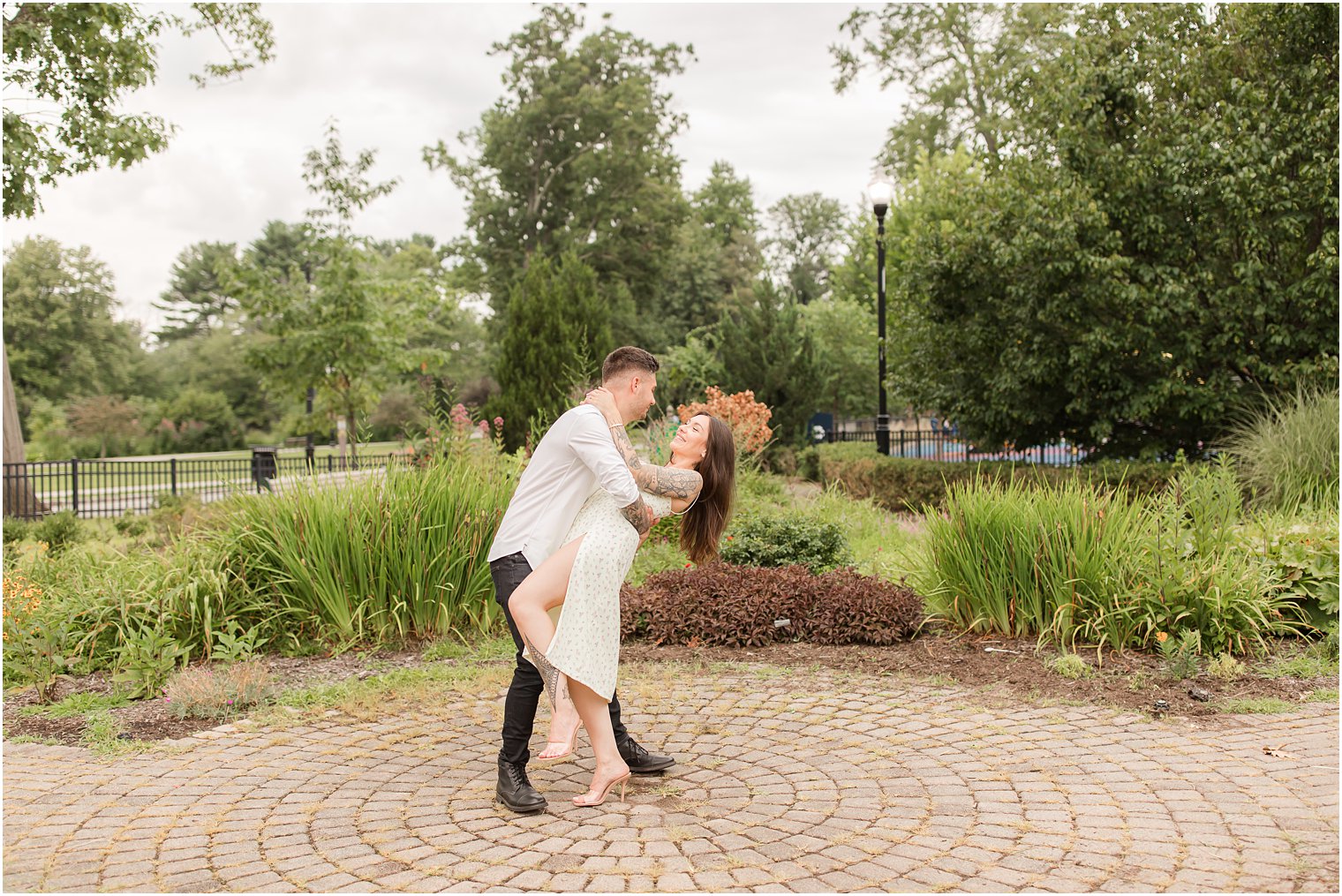 groom dips bride during Verona Park engagement session 