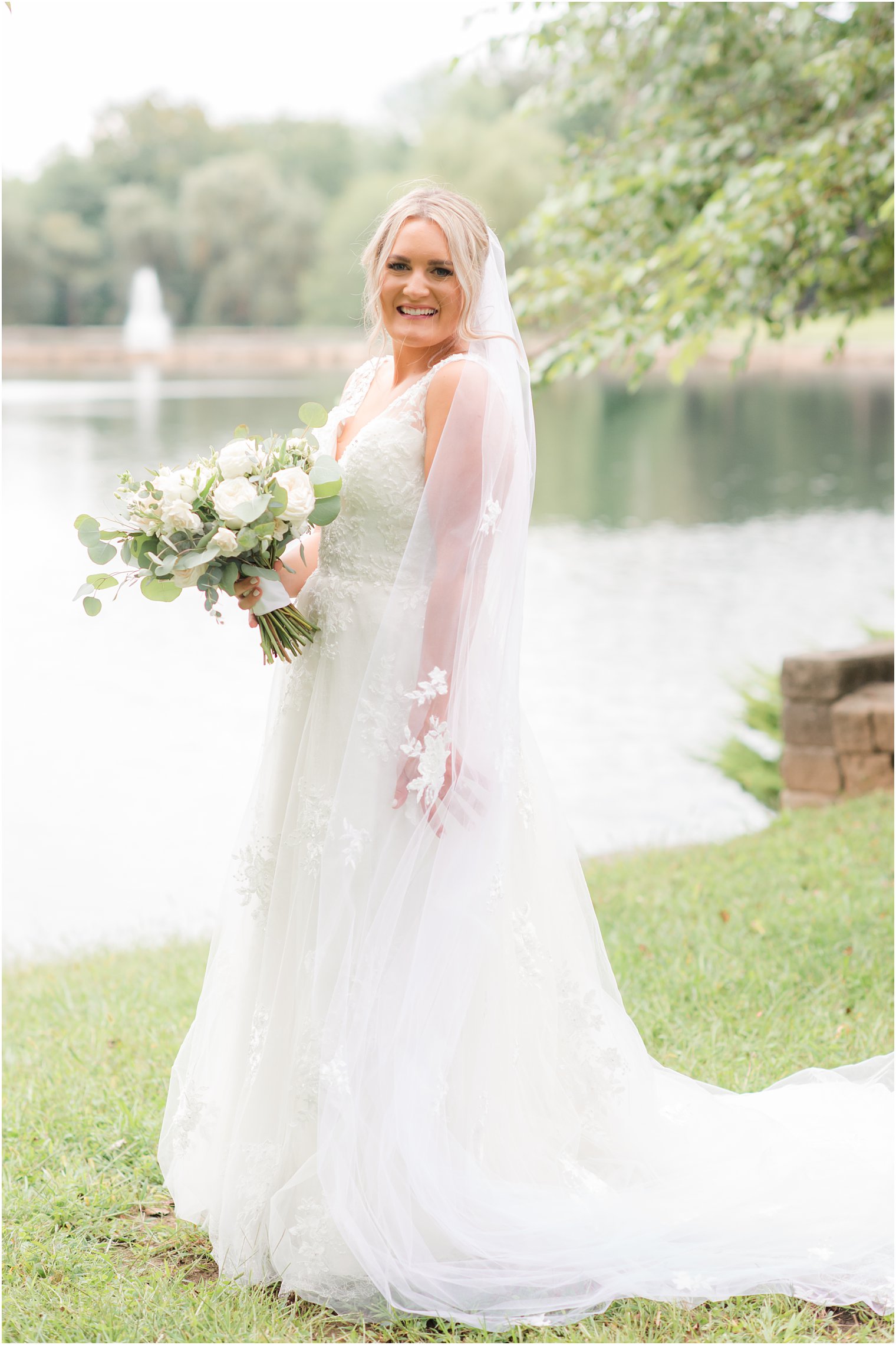 bride holds veil around side during Windows on the Water at Frogbridge wedding photos