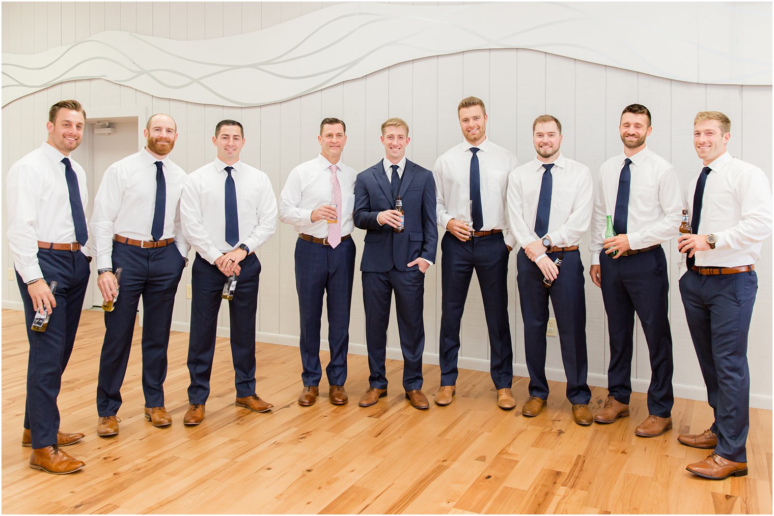 groom and groomsmen pose with beers